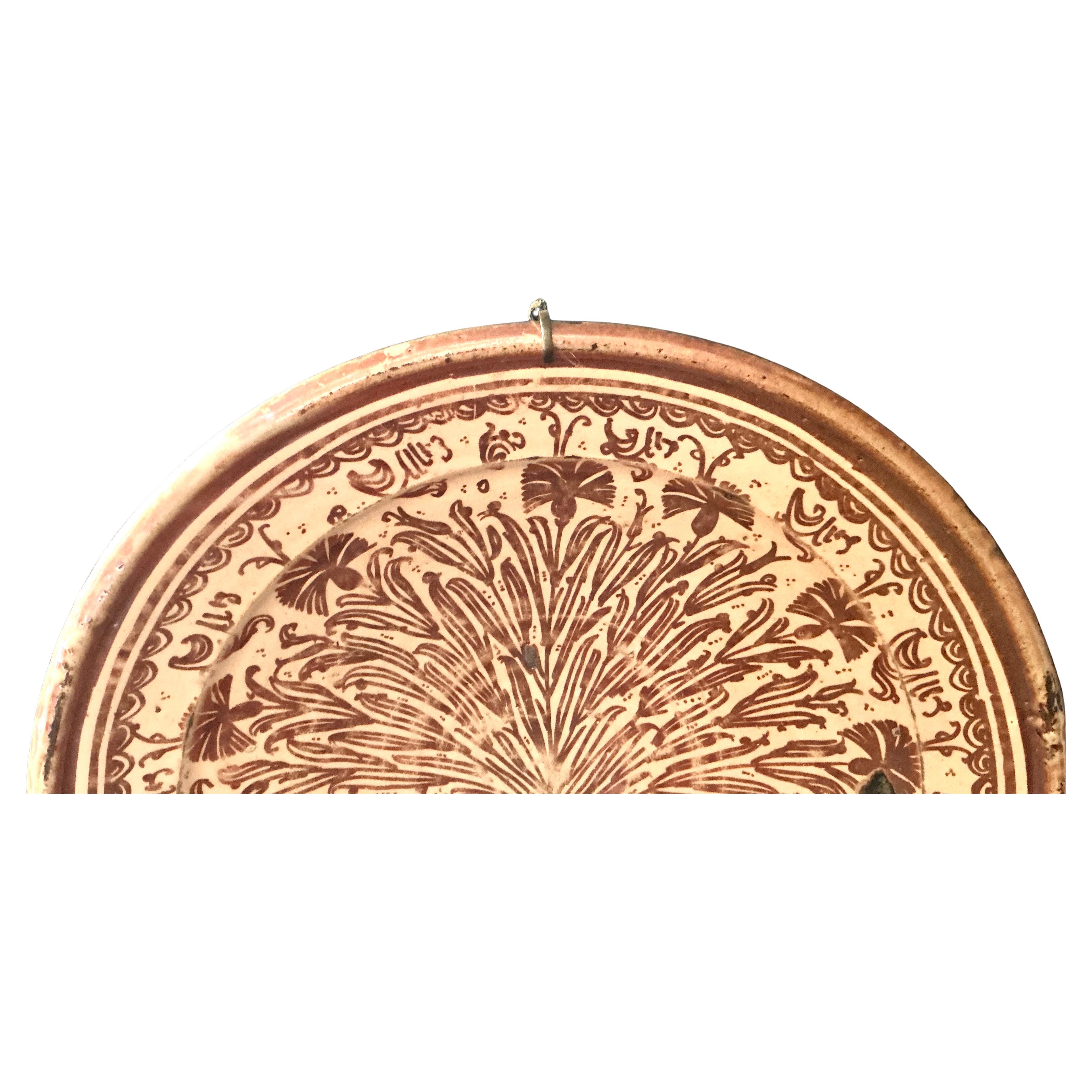 Large 17th Century Hispano-Moresque Lusterware Pottery Charger. The charger features a deep rounded form with a rich terracotta glaze over a cream background. The central design radiates with a stylized foliage or palm motif, delicately hand-painted