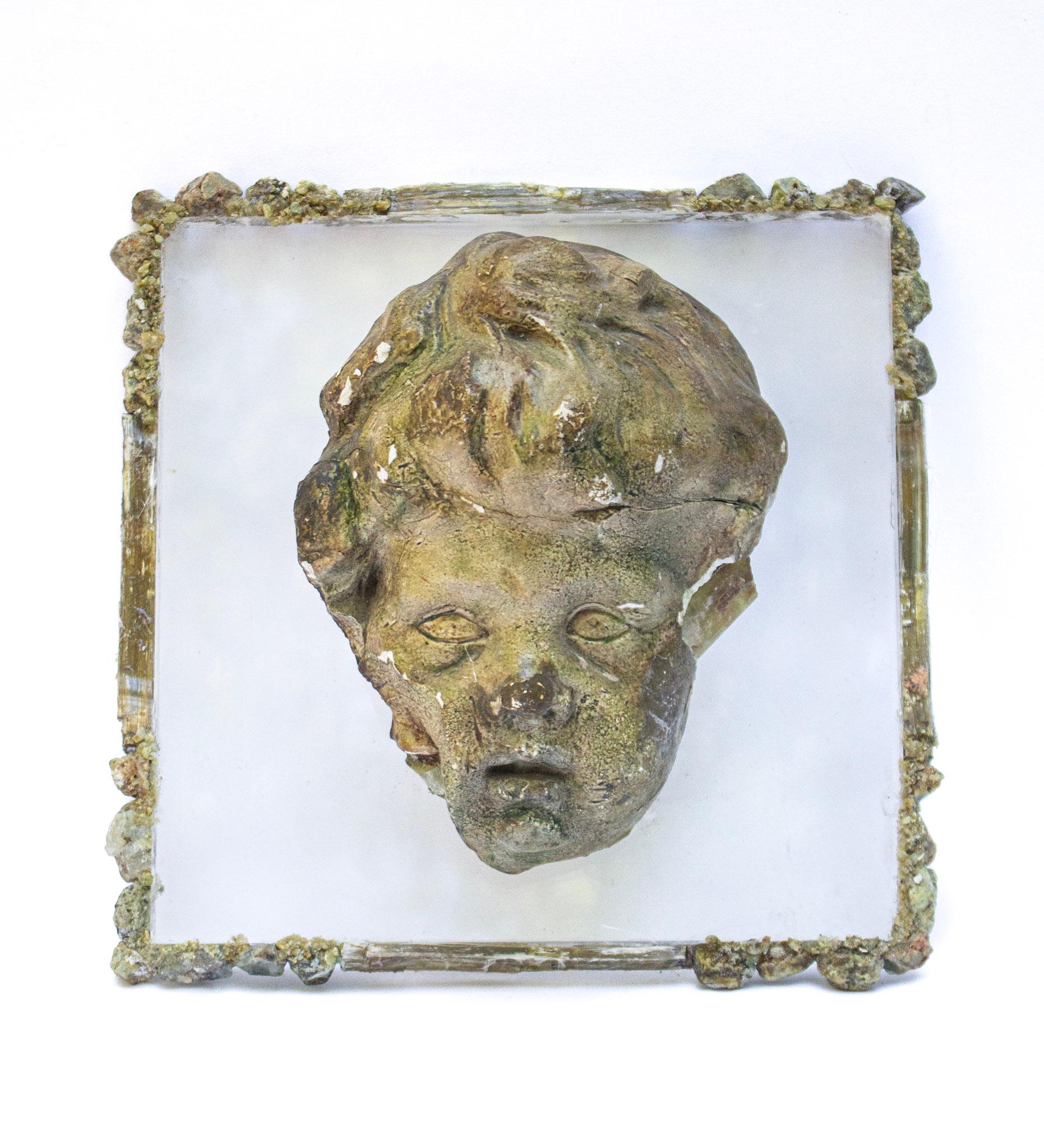 Tête d'ange italienne du 17e siècle en plâtre sculpté à la main avec péridot coordonné sur lucite et encadré d'émeraude et de mica en formation naturelle. Le putto (tête d'ange en italien) a subi une dégradation naturelle avec l'âge et faisait à
