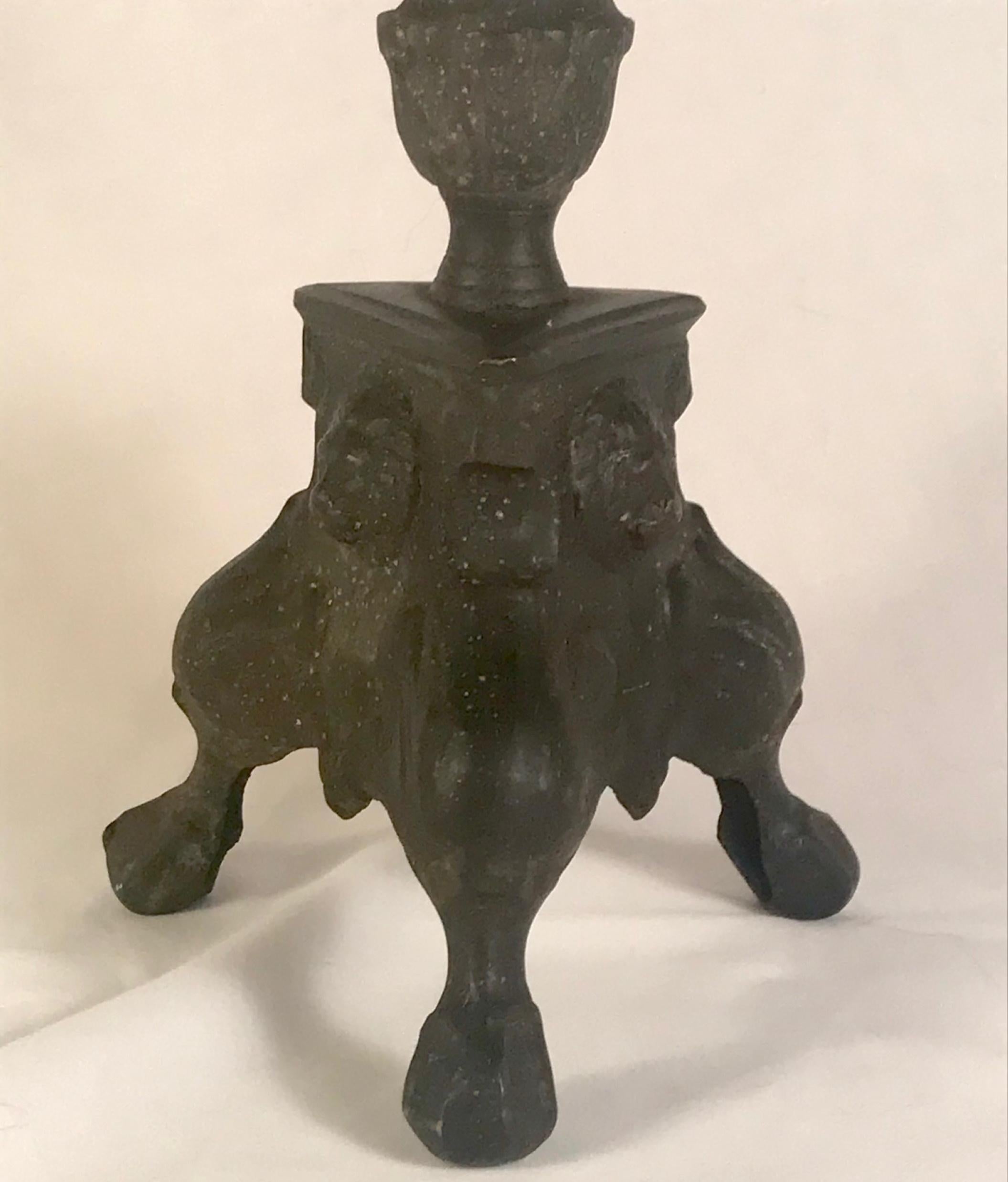 17th century Italian Baroque bronze Paschal candlestick.

This early Italian Baroque candleholder stands on a claw footed tripod base that supports a turned shaft and pricket stick bobeche. Three sides are decorated with lion head medallions. The