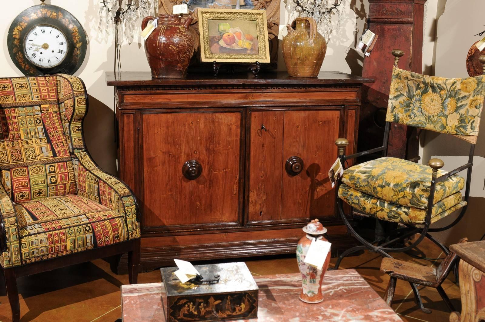 The Italian pine credenza with rectangular top, dental molding and 2 cabinet doors below with turned wood pulls and all resting on bracket feet. 

  