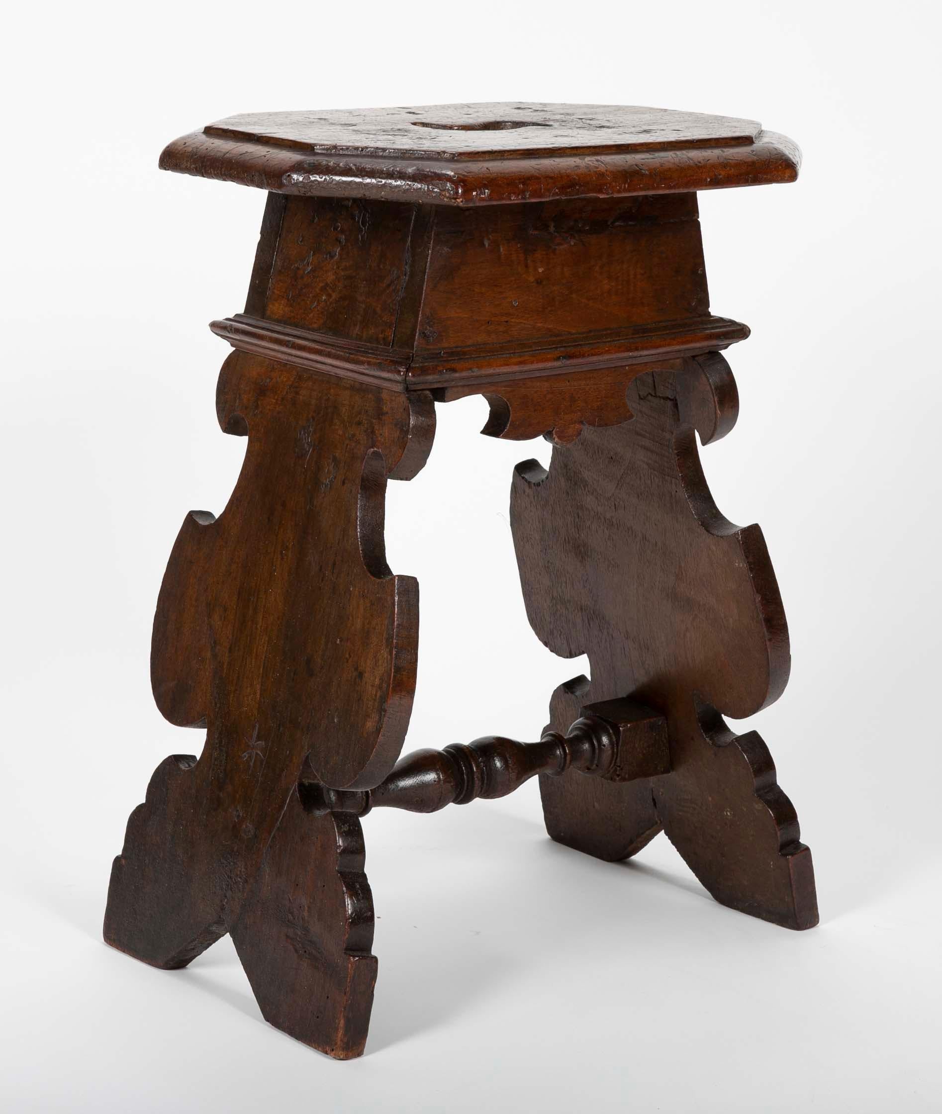 Rare late 16th or early 17th century Italian walnut stool. The sides showing signature baroque profiles joined by a turned stretcher. The thick octagonal top with molded edge and center cut opening for easy lifting. A handsome form, taller than a