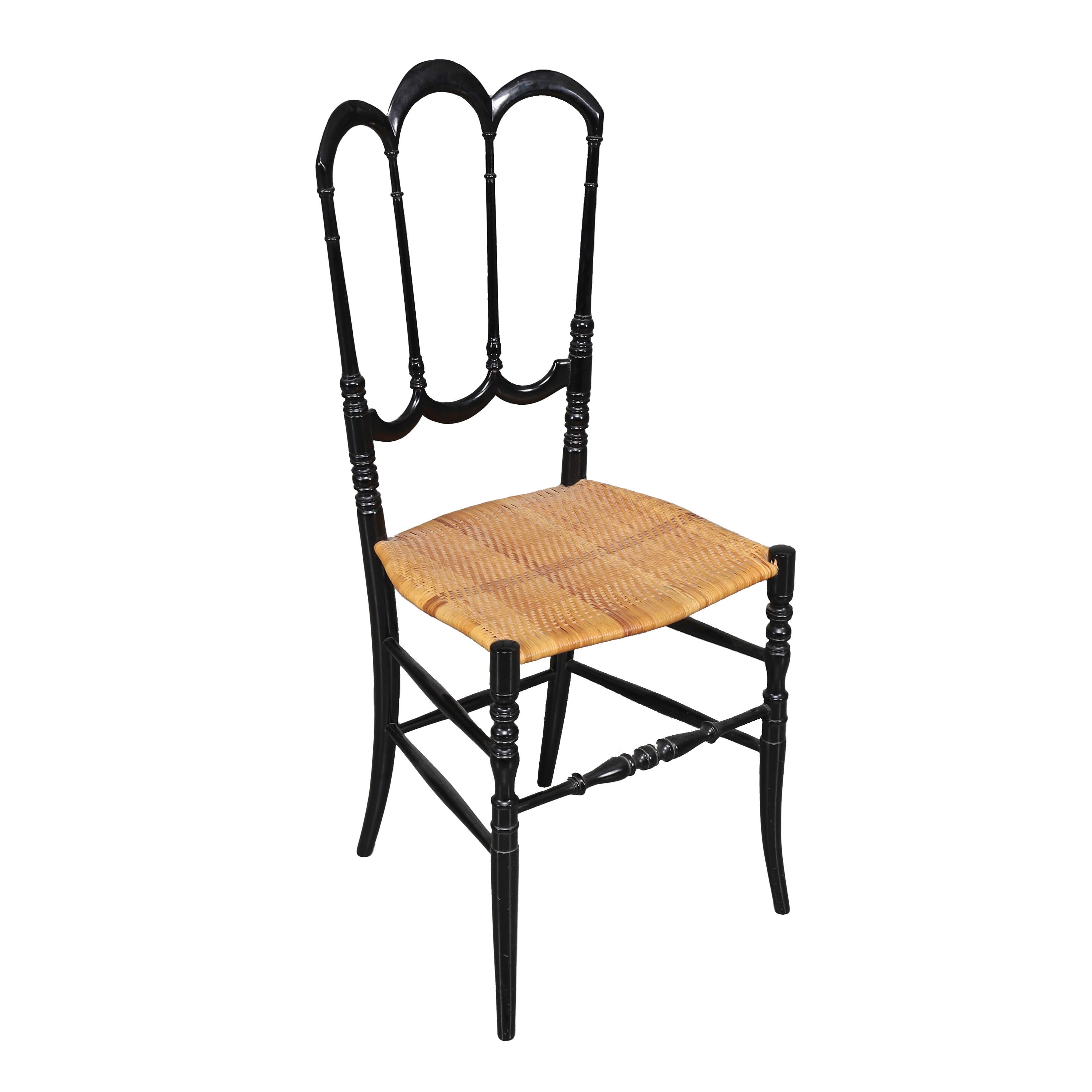 Nous vous proposons de considérer une chaise Chiavari solitaire, laquée noire, dans un bel état vintage. Avec ses pieds tournés, son cadre et son dossier en saule pourpre sculptés à la main dans un style Empire sobre du XVIIe siècle, il est peint en