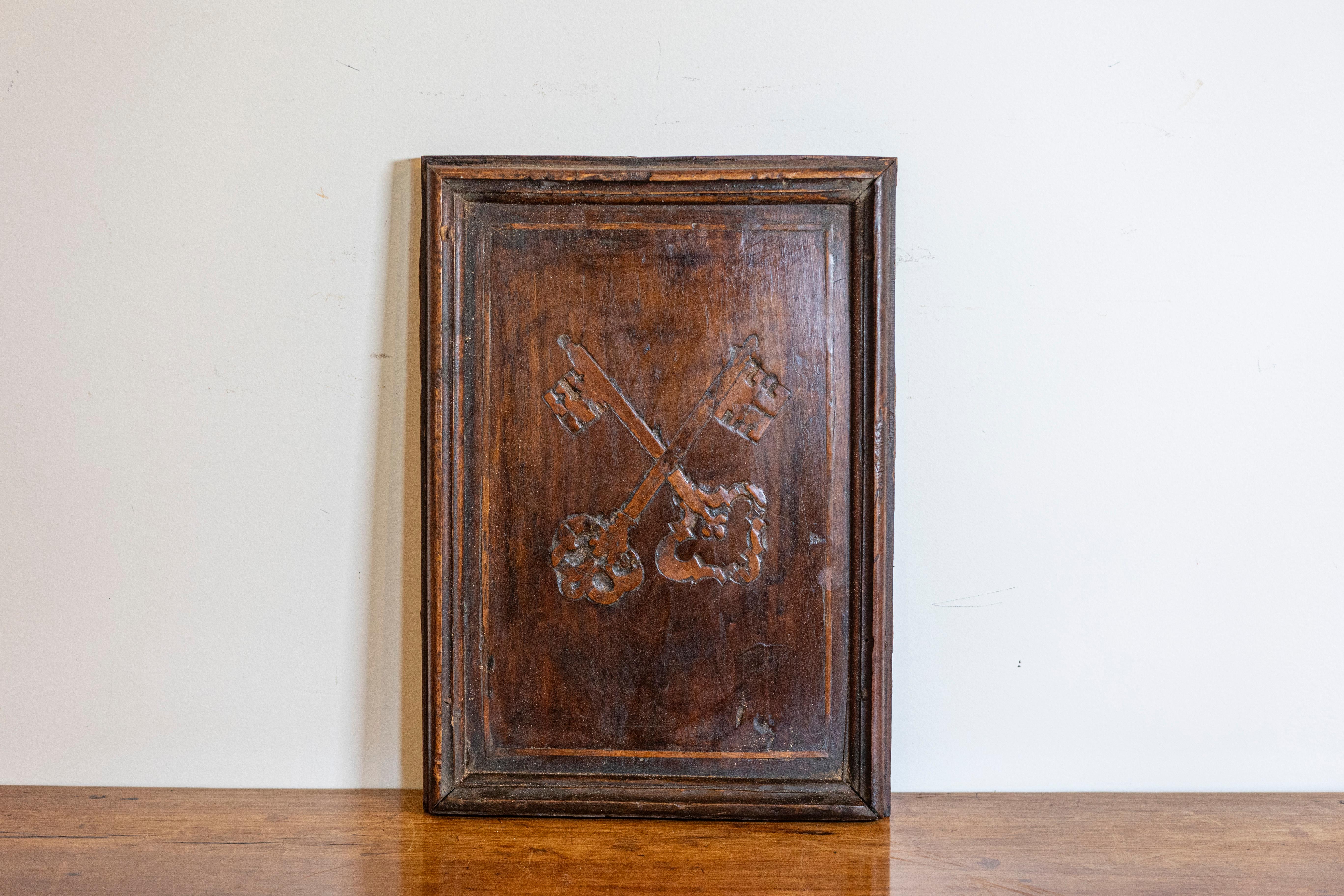 A distinguished 17th Century Italian carved wooden panel, showcasing the artistry and craftsmanship of the Baroque period. The panel is meticulously carved with an intricate design featuring a pair of crossed keys, a motif often associated with