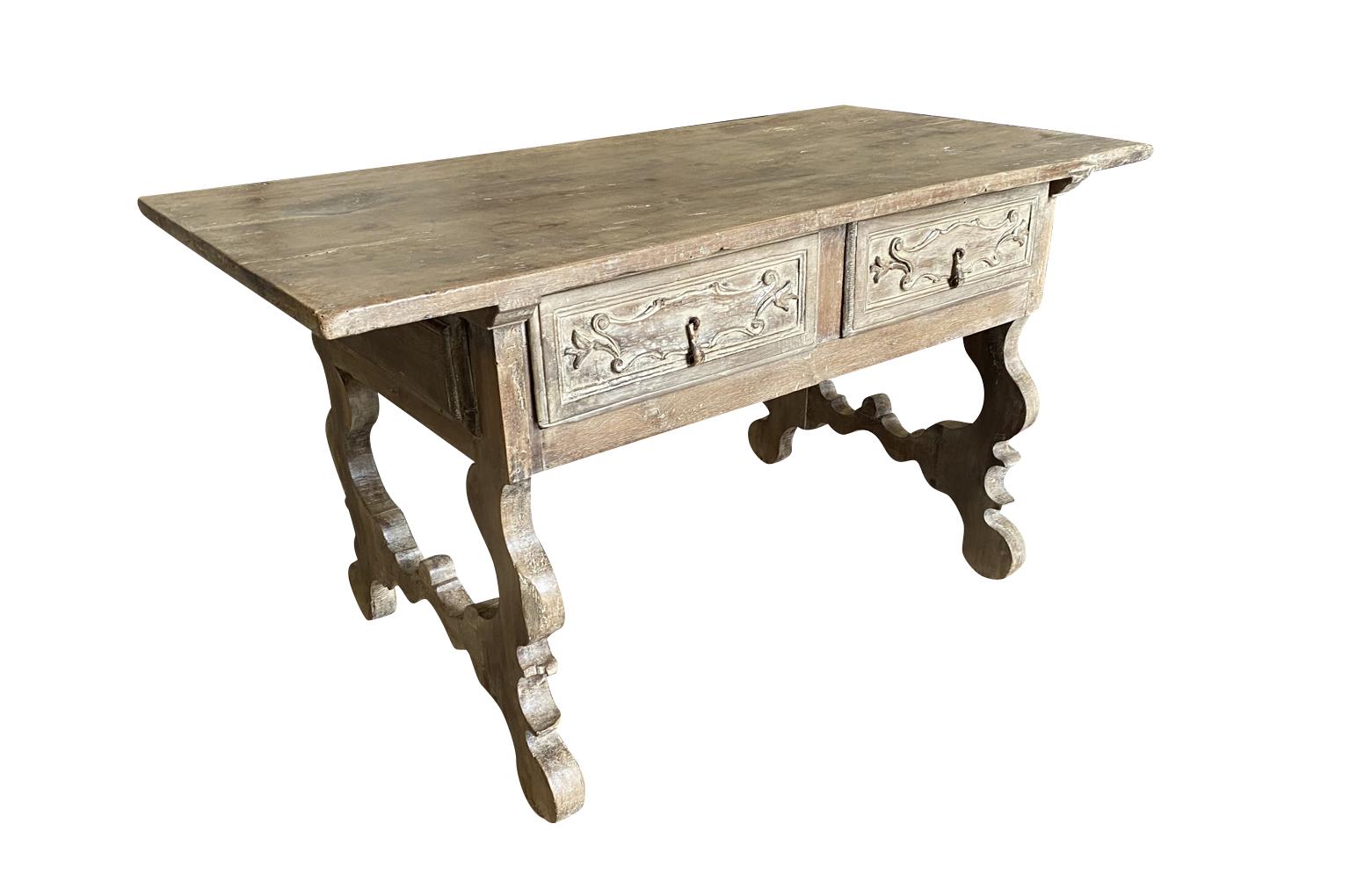 Très belle table centrale - table à écrire du 17e siècle provenant de la région de Bologne en Italie. Magnifiquement construit en noyer avec deux tiroirs, des pieds en forme de lyre classique et un plateau en bois massif. Étonnant.