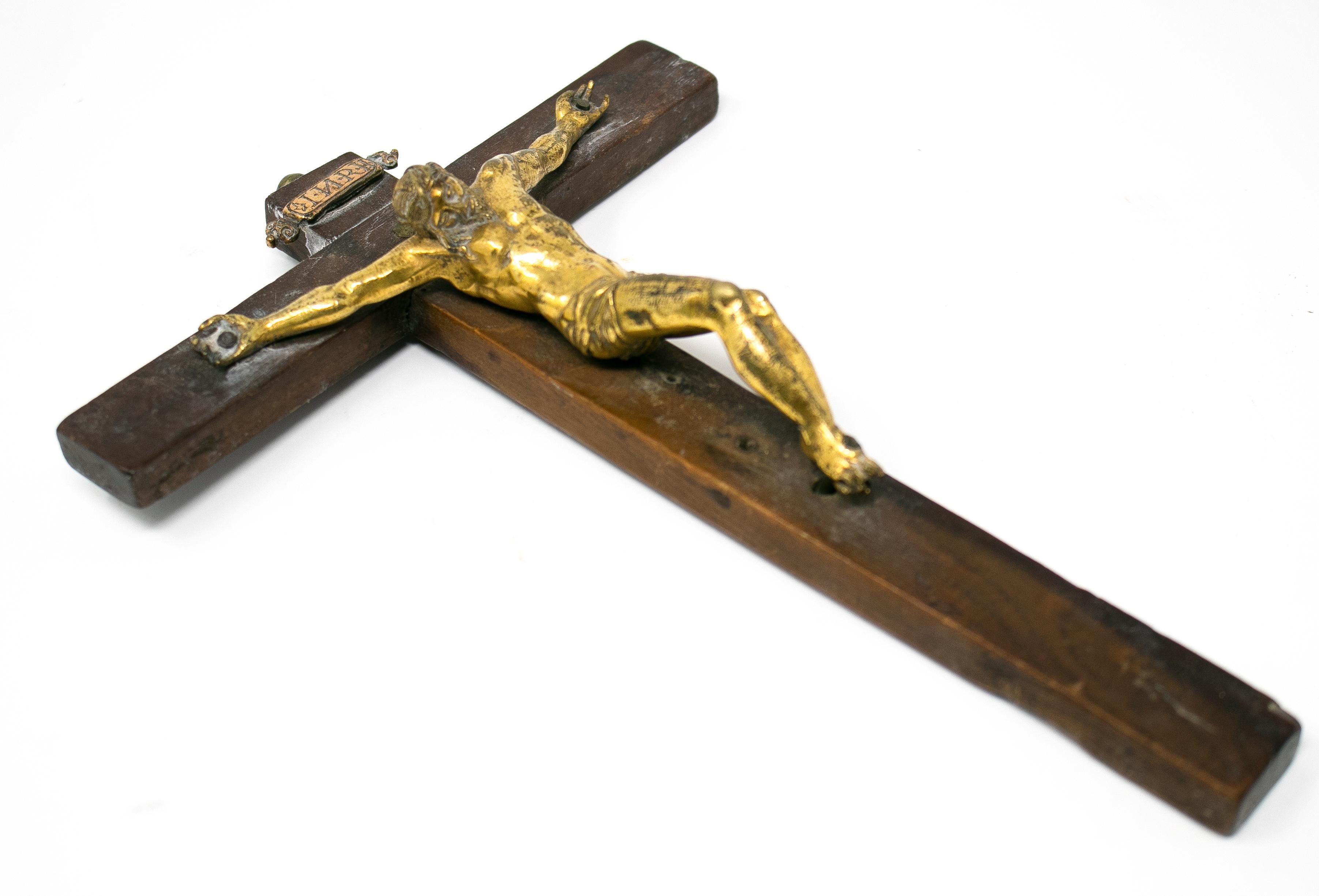 17th century Italian crucifix with golden bronze Christ on a wooden cross.