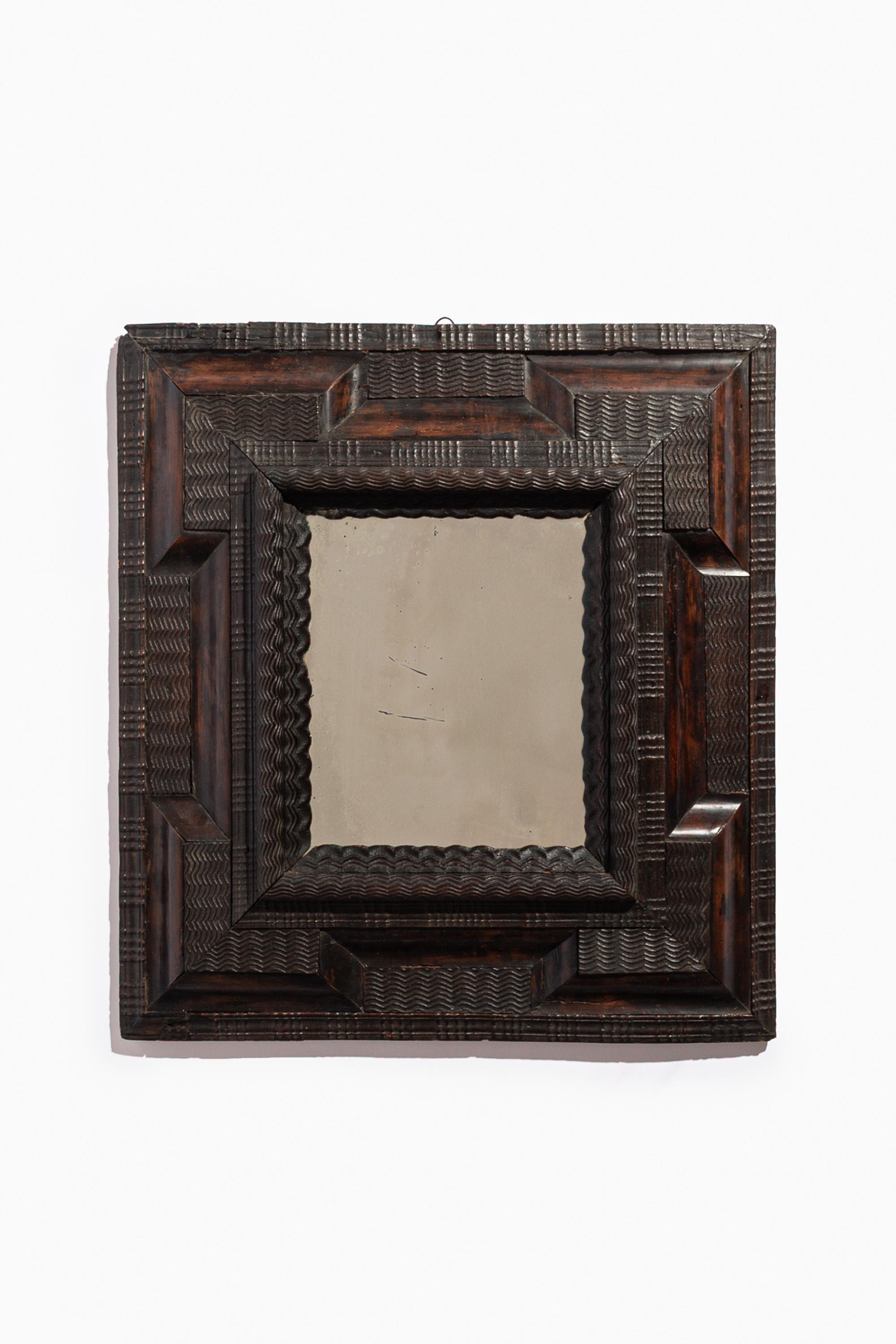 Merveilleux miroir italien du 17e siècle en guilloché ébonisé avec moulure ondulée sculptée. Luigi XIV, Piémont.

La plaque rectangulaire est entourée d'un cadre en forme de coussin avec des moulures convexes et sculptées.

Usure mineure liée à