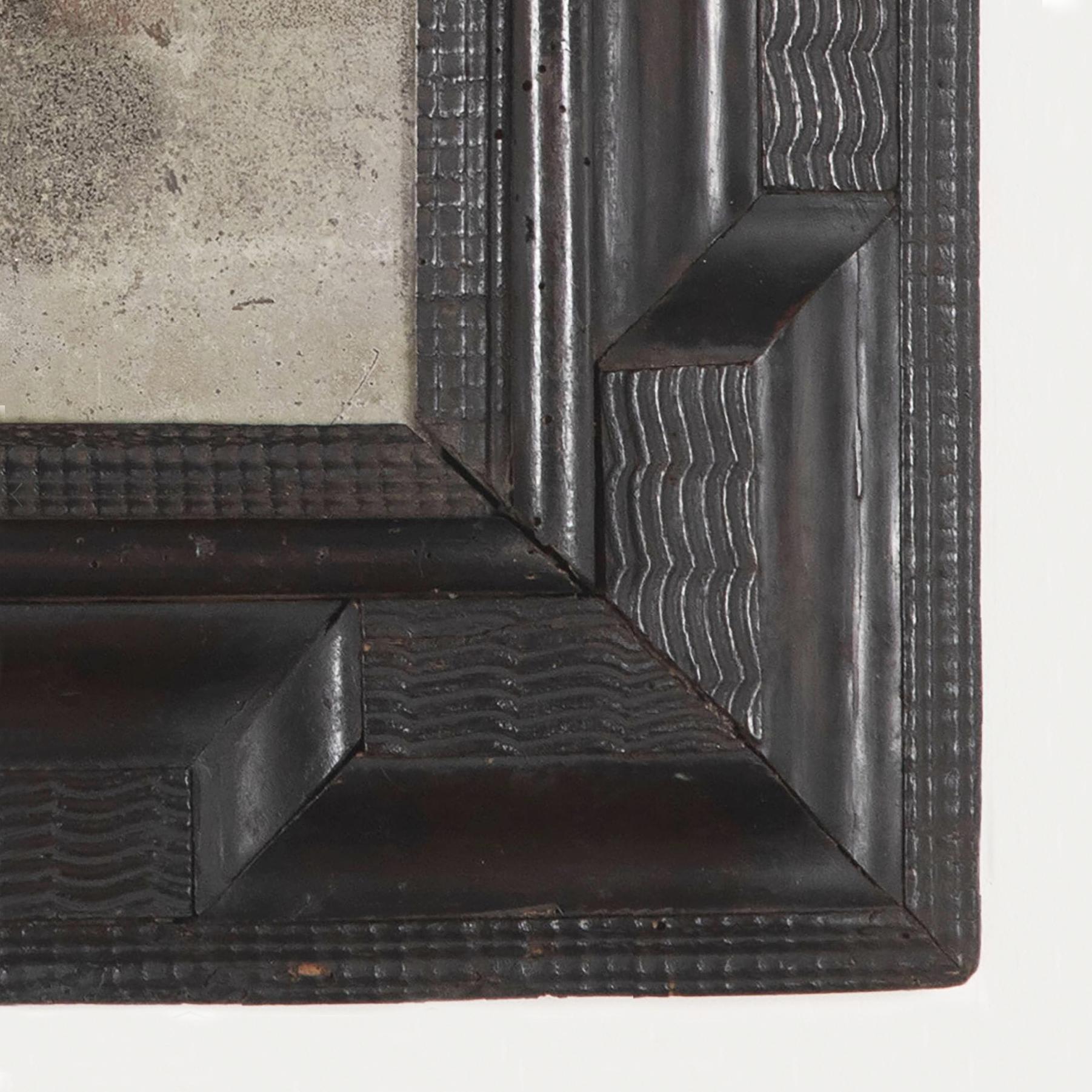 17th Century Italian ebonised pearwood mirror with carved ripple moulding. 

The rectangular plate within a cushion frame of convex and carved ripple moulding with inner eared corners. 

The plate possibly original, minor age related and expected