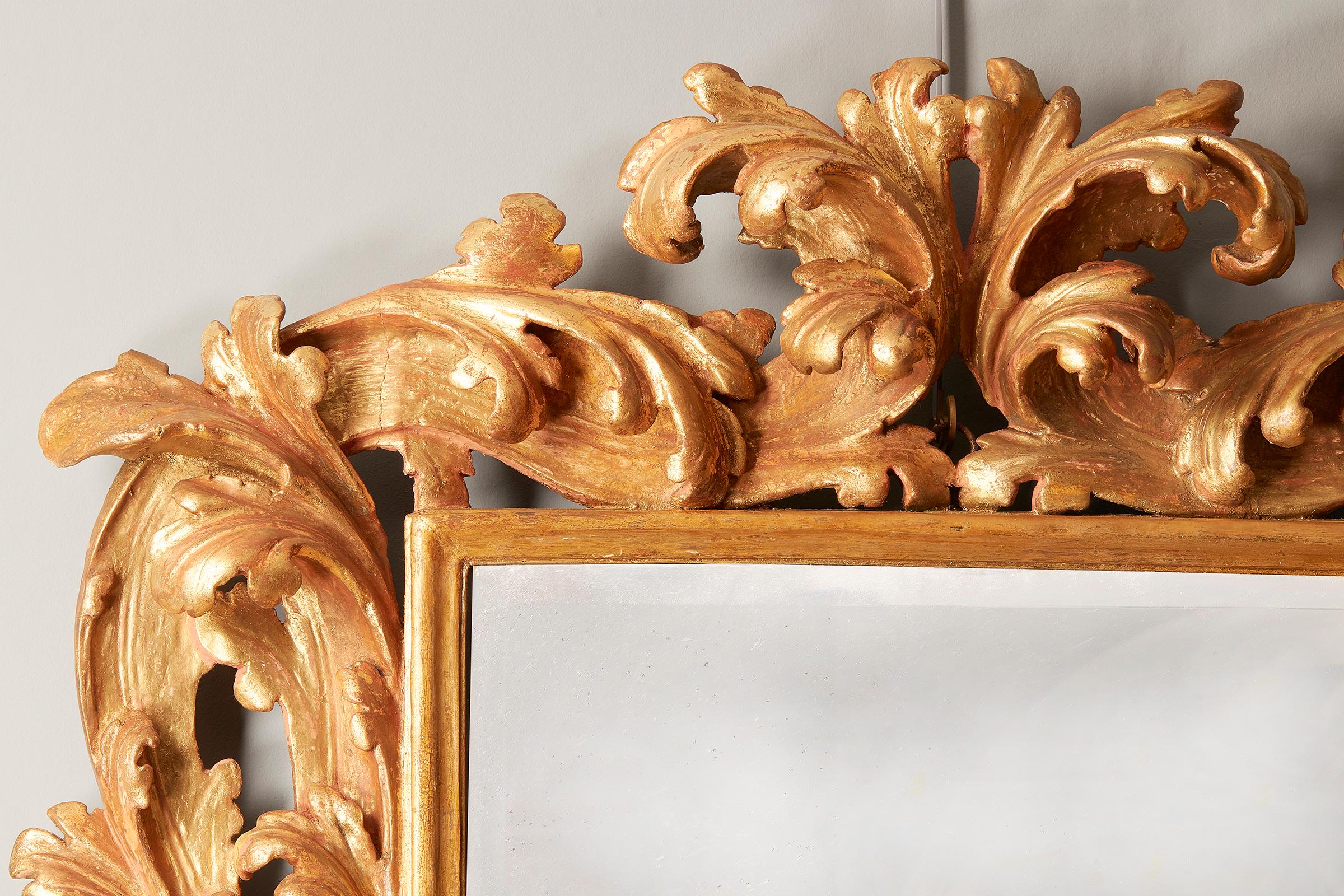 An Italian carved giltwood mirror, late 17th century, rectangular beveled plate, leaf scrolling frame, later re-gilt

Provenance: Count Redmond Toler Clayton-Browne Clayton (1863-1937) of Villa La Punta, Cervara, Santa Margarita, Liguria.