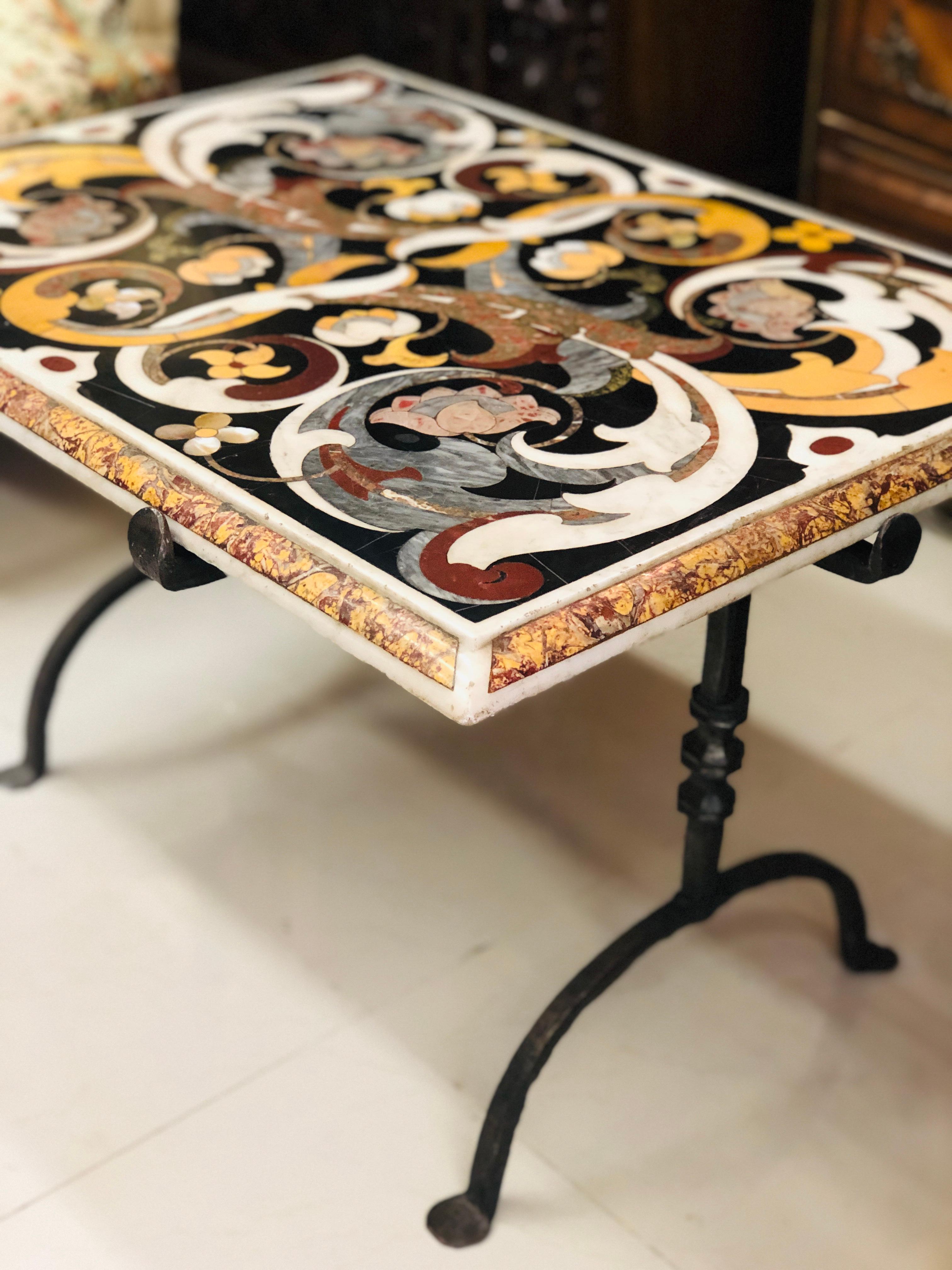 Rare table en marqueterie de marbre multicolore reposant sur des pieds en fer forgé.
Fabriqué au XVIIe siècle dans le style typique de Florentine, avec de nombreux motifs floraux sur une base noire.