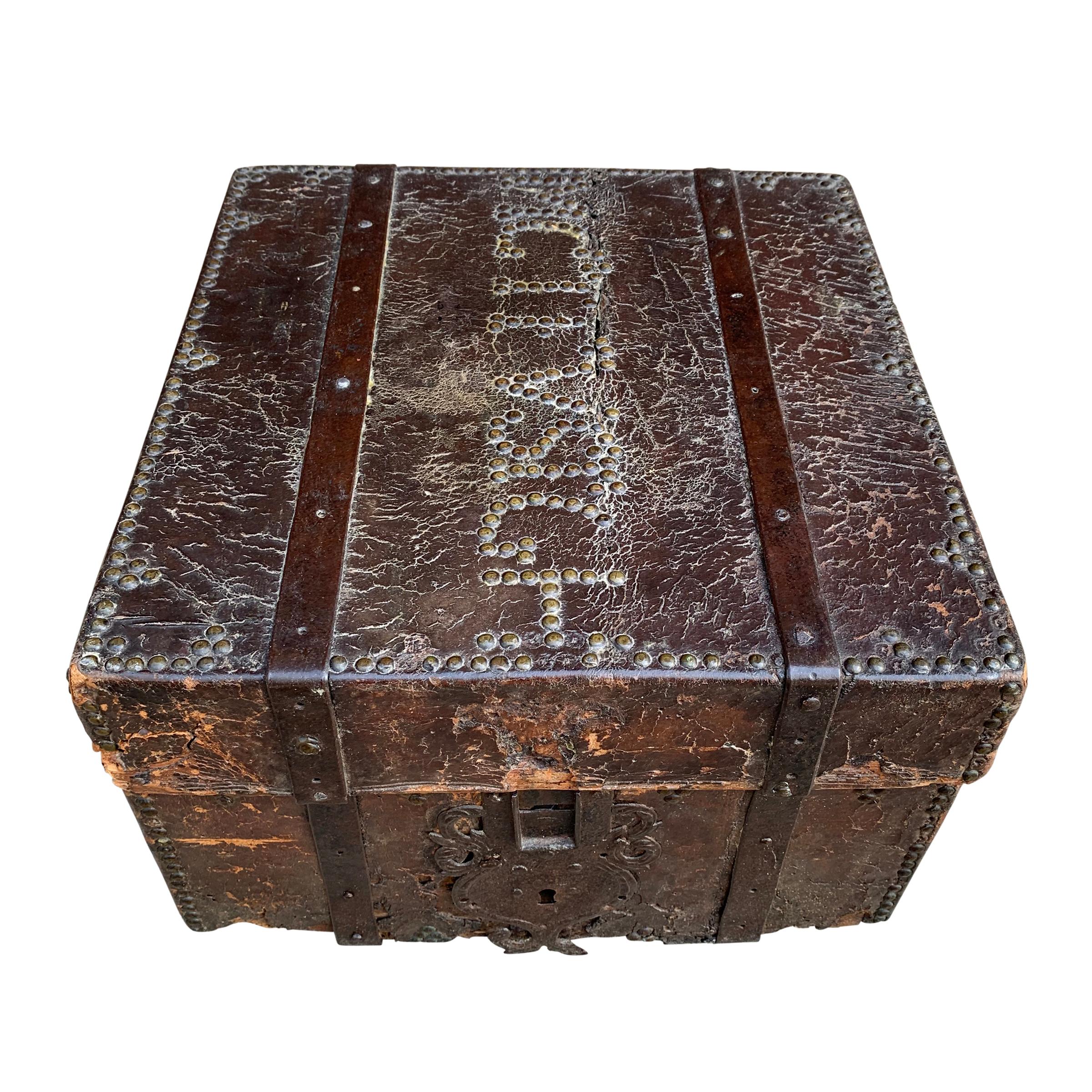 An incredible 17th century Italian leather clad lock box with beautiful well-worn brass nailhead trim in a decorative pattern, with a gorgeous wrought iron escutcheon, and lined with hand painted paper. The clasp and key are missing, therefore the