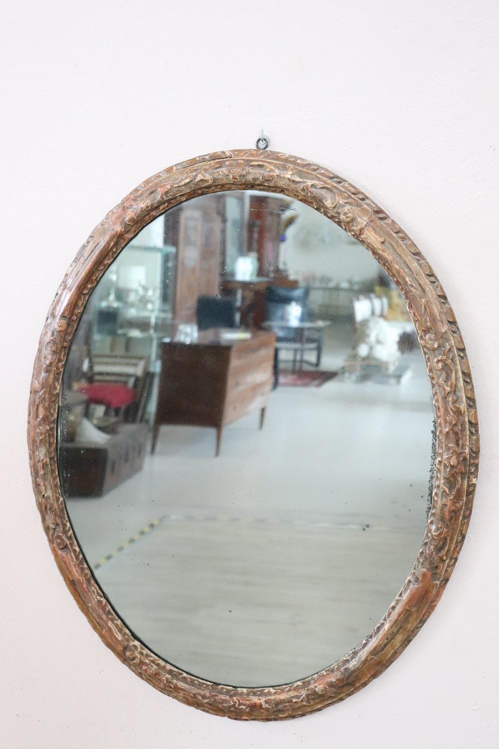 Beautiful elegant antique oval wall mirror. Italian Louis XIV 1680s. Hand carved wood with finely and richly swirls and curls. Antique mercury mirror. In good antique conditions.