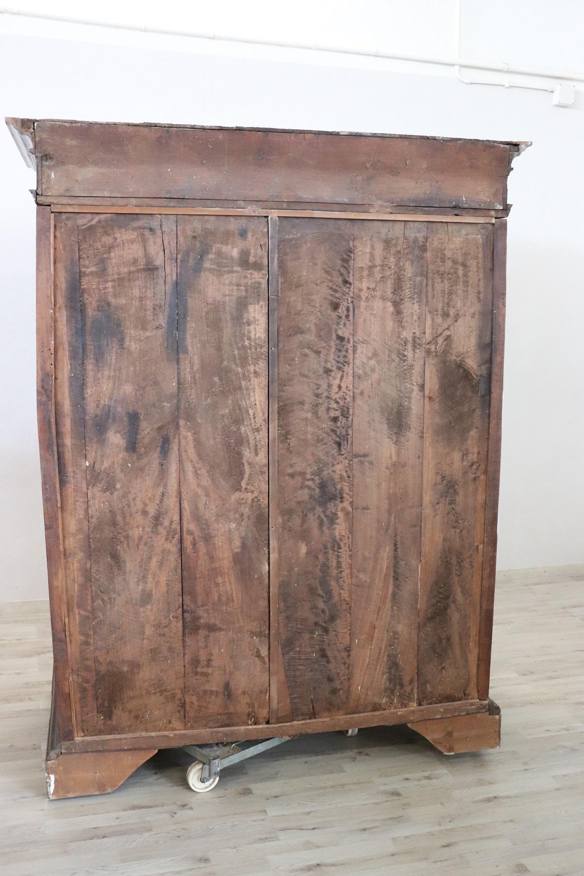 Rare and important antique wardrobe in solid walnut made in the late 17th century Italian Baroque Louis XIV. The line is in fact typical of this period of high period that wanted this type of furnishings of great grandeur made of solid walnut wood