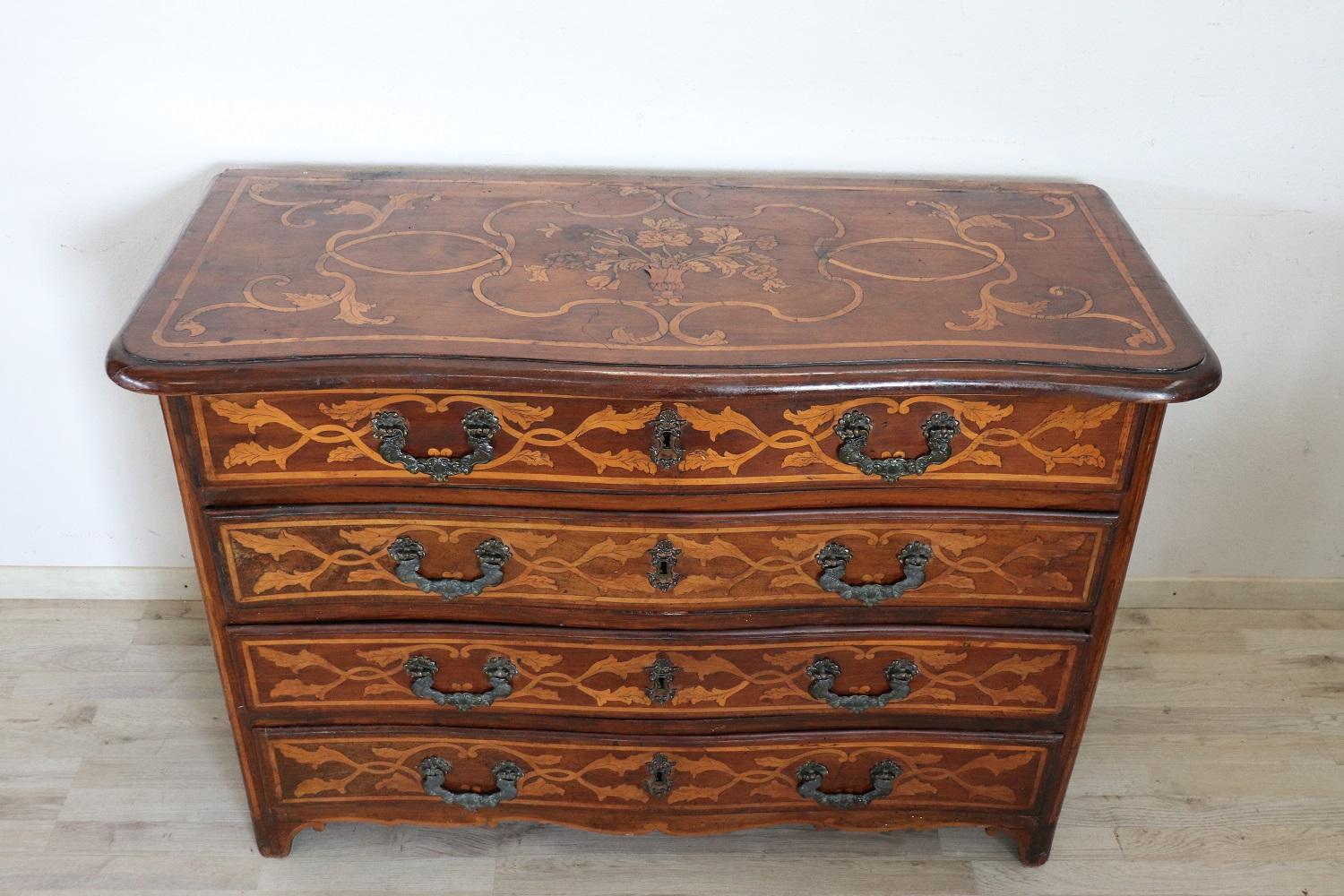 Important antique Italian Louis XIV period chest of drawers 1680s. On the front four large and useful drawers with a particular wavy shape. This chest of drawers is characterized by a spectacular and rich inlay work in walnut wood, made with