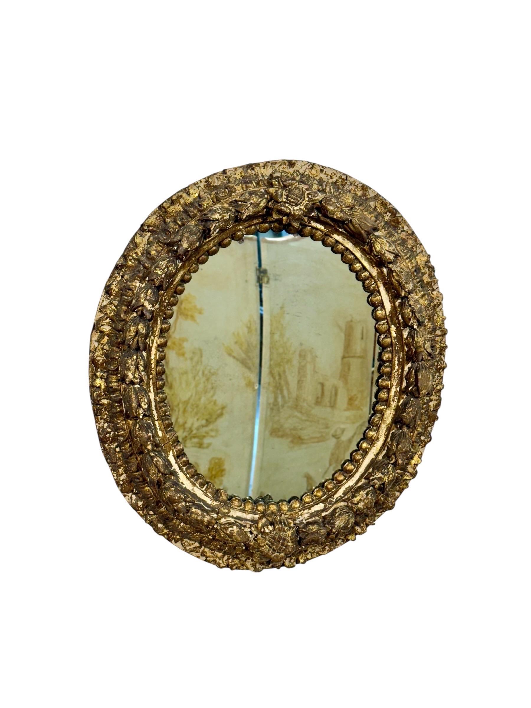 Sculpté à la main Miroir ovale en bois doré italien du 17e siècle avec sculptures florales en vente