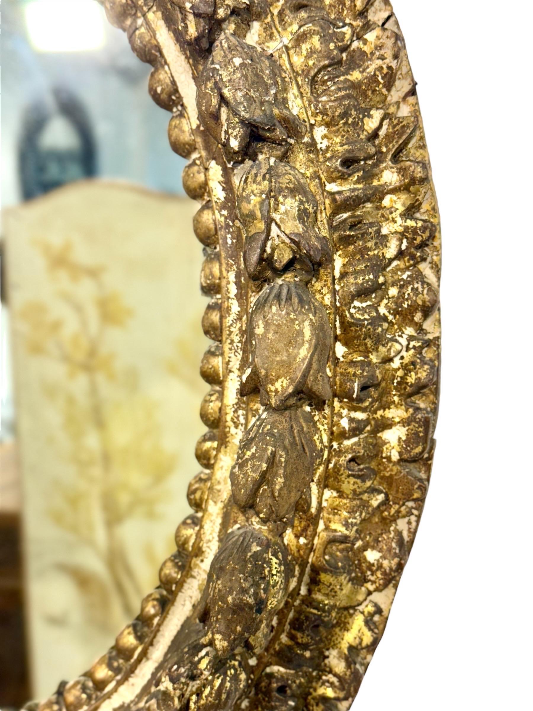 Verre mercuré Miroir ovale en bois doré italien du 17e siècle avec sculptures florales en vente