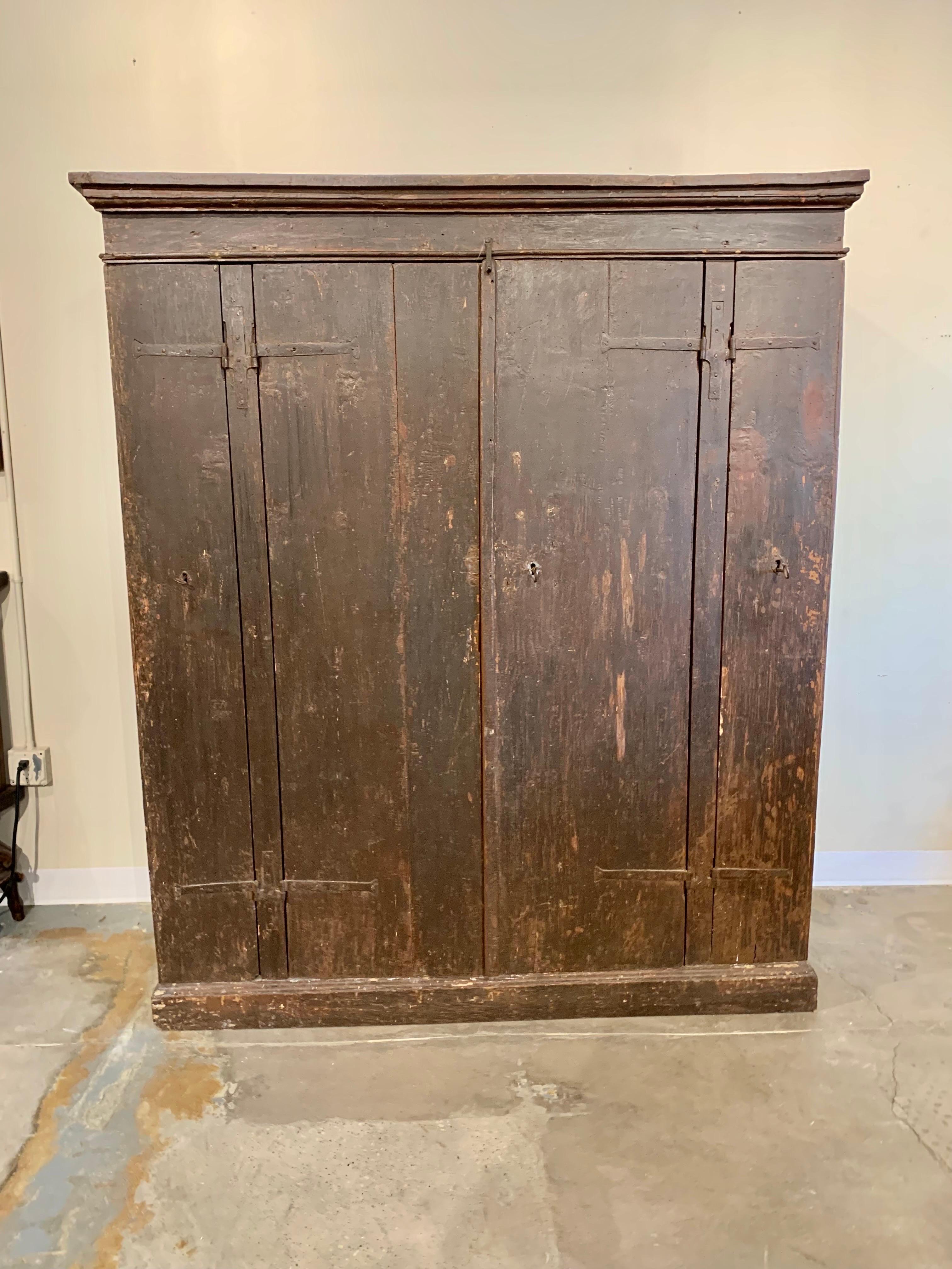 Found in Italy, this 17th Century Four Door Cabinet or Cupboard once graced an Italian countryside villa.  Hand crafted from old growth pine and forged iron hardware the piece features two large center doors and two smaller doors on each side.  The
