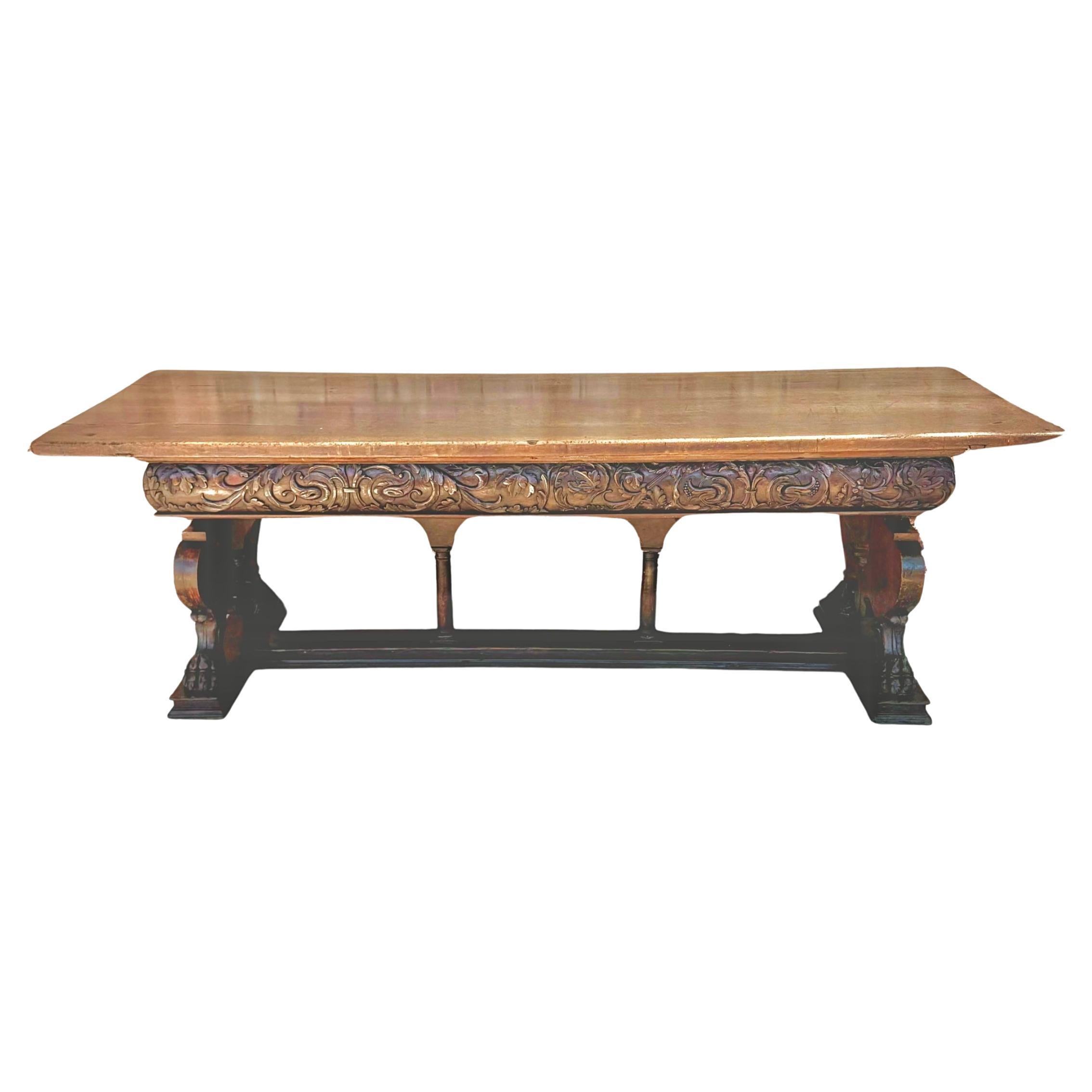 Stunning 17th century Italian Renaissance walnut center table. Table features a rectangular top above intricately cared frieze on wide carved end pieces, culminating in large paw feet. Table is supported by a large thick beam stretcher. Wood retains
