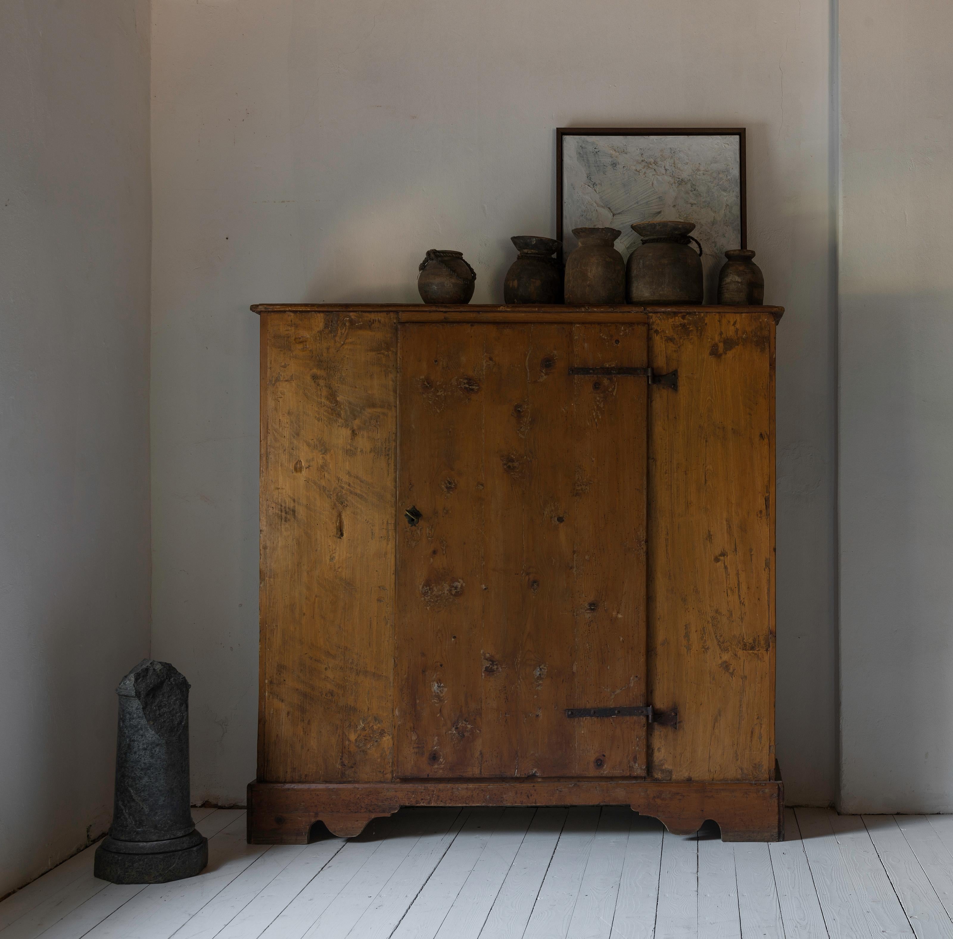 An incredibly simple 17th century Montagnard wardrobe with original wrought iron hinges and a beautiful honey-coloured patina. One central door on the straight front. Feet in shelf. 

Can be used as a linen press, a TV cabinet, a slightly smaller