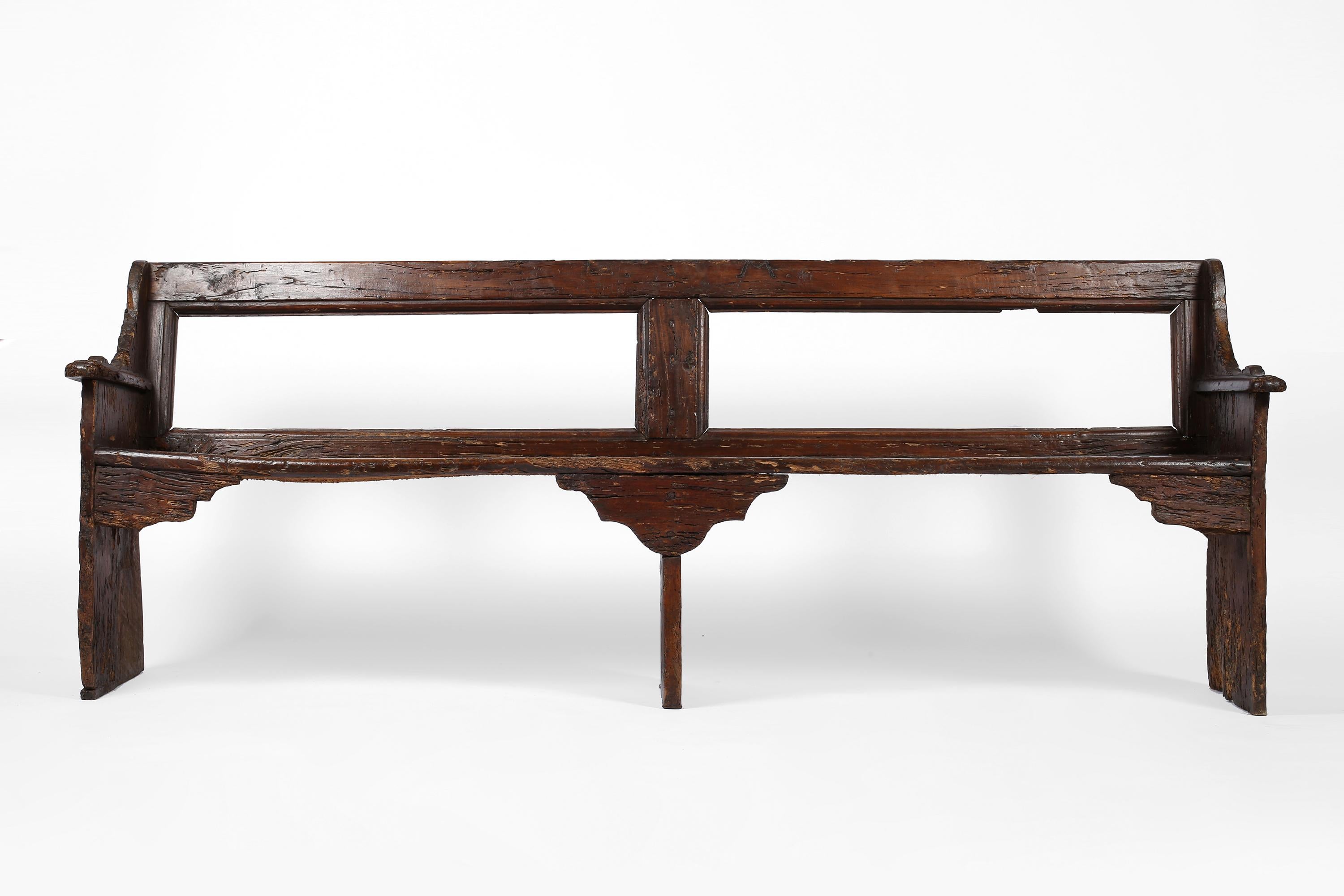 A rare surviving large 17th century walnut bench from Tuscany. Heavily patinated and full of character, with historic repairs adding to its charm. Bearing the letter M to the backrest - likely to identify the original owner or maker of the bench.