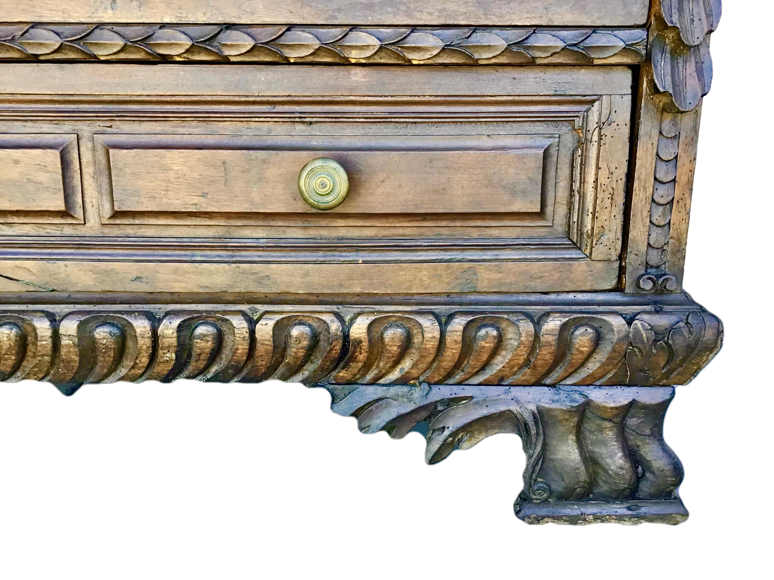 Fabulous chest of drawers in solid walnut with 4 drawers. This Baroque walnut commode from Italy is exquisitely flanked with a pair of carved side posts and 
beautifully hand-carved detail throughout. Original base with oversized winged paw feet.
