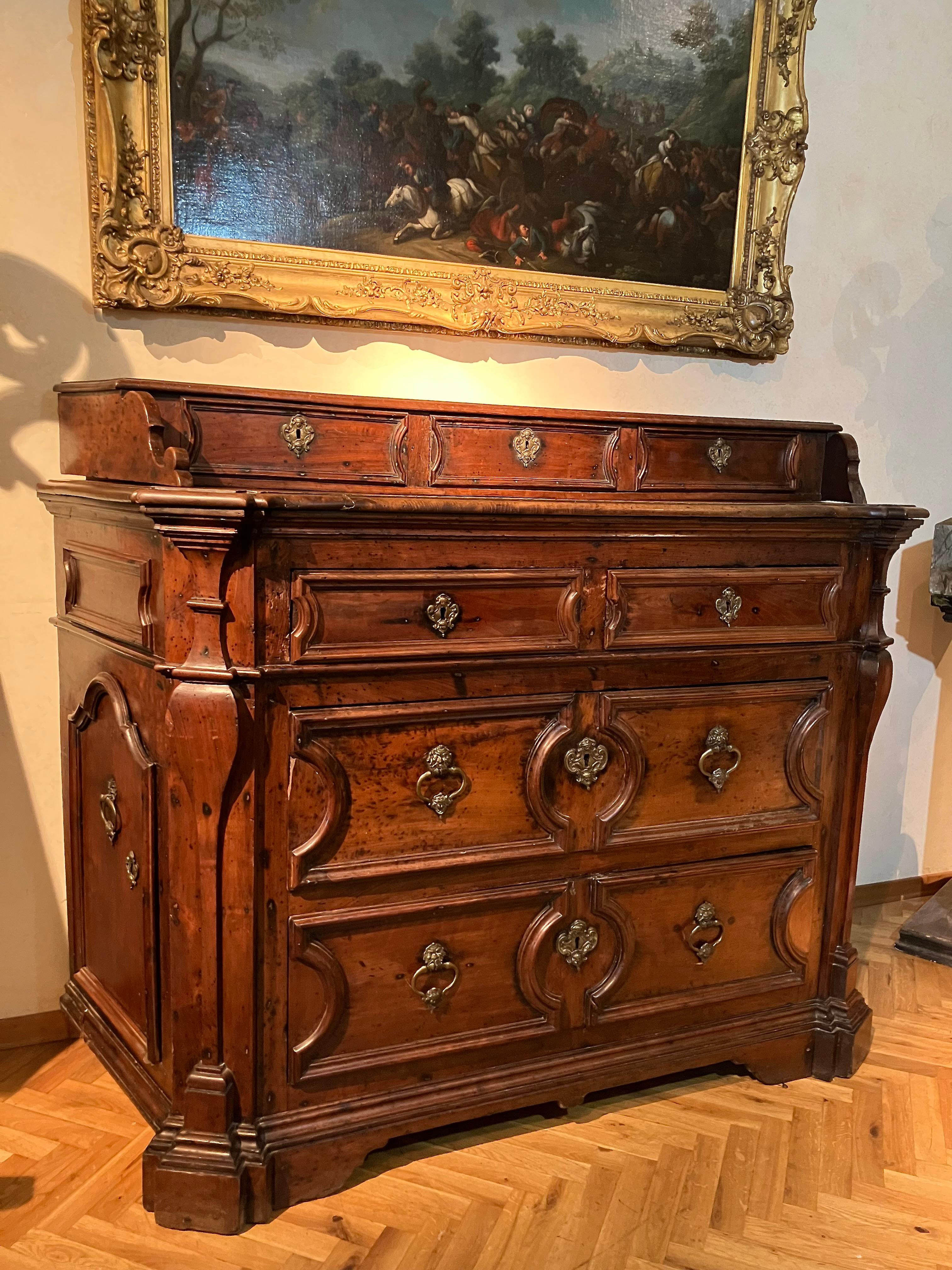 This magnificent Italian 17th-century solid walnut chest of drawers (canterano), is a testament to the craftsmanship of Roman Baroque and Louis XIII reign splendor. 

Believed to have originated from the Vatican State, this imposing cabinet exudes a
