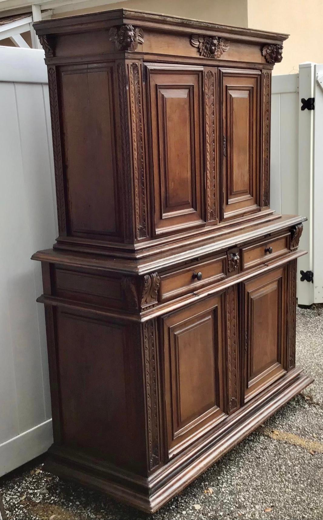 Beautiful rare large 17th century Italian Baroque Cabinet. In two parts with cabinet doors above and below and drawers in the middle. Carved with leaf design and cherubs or angels around the cornice. Wonderful old patina. Expert craftsmanship. A