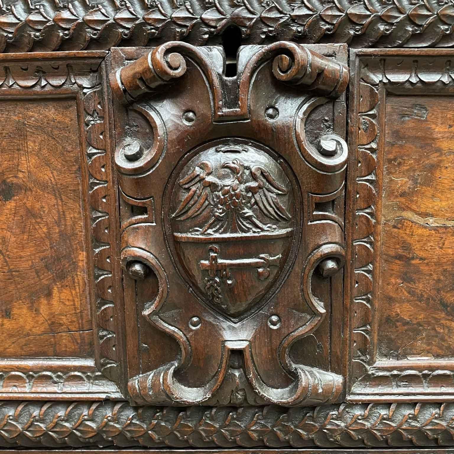 From Italy,  Bergamo this fabulous, beautifully hand-carved walnut wood trunk was made in the 1600s. The top and sides have no decoration, reserving the attention for the elaborate front panel, with Coat of Arms  of Pesenty family in Bergamo, a