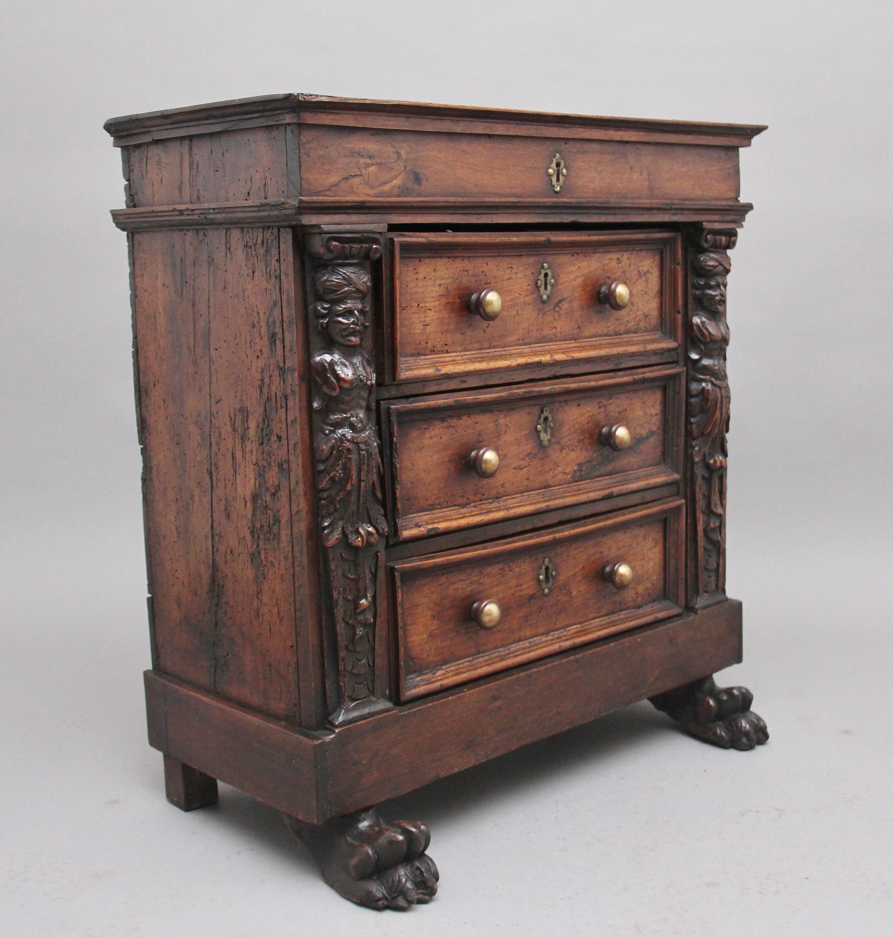 An unusual and rare 17th century Italian walnut chest, the top having a hinged lift up top to reveal a spacious compartment, three drawers below with moulded edges and original brass knob handles and escutcheons, the drawers flanked either side with