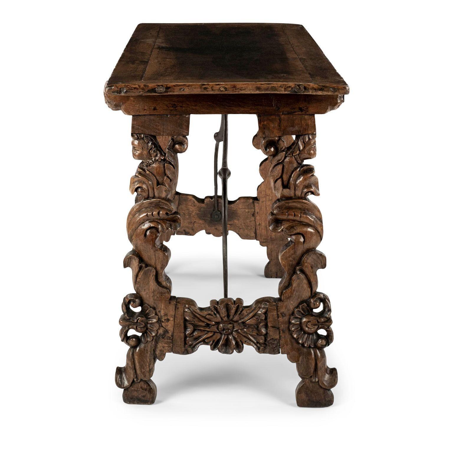 17th century Italian brown walnut console table circa 1660-1690. All-original: rectangular top, scrolled iron trestle support, ornately carved feet/legs and remnants of original - or early - asphaltum finish. Exceptional example of an early