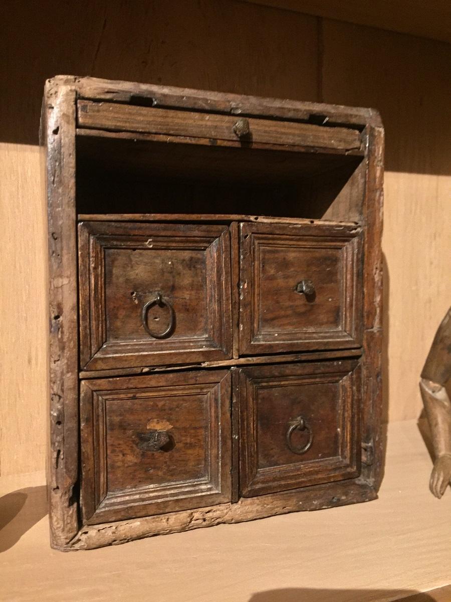 Rustic and delicate miniature travel cabinet. Very finely executed in large boards of fine walnut. All sides traditionally dovetailed. The design, fabrication method and patina of this piece date it to the 17th century.
 