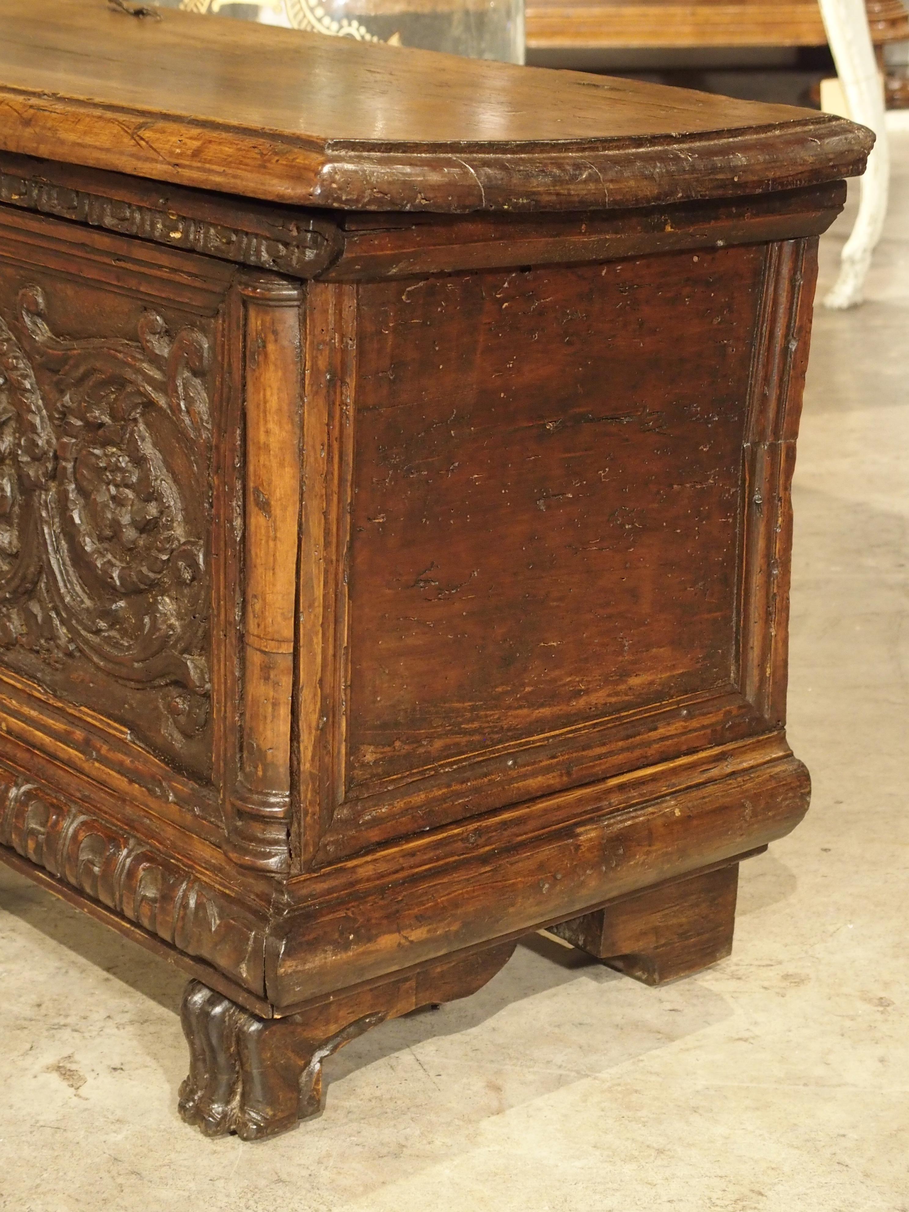 From Italy, this fabulous, beautifully hand-carved walnut wood trunk was made in the 1600s. The top and sides have no decoration, reserving the attention for the elaborate front panel. There is a linear carved molding on its front edge. At the