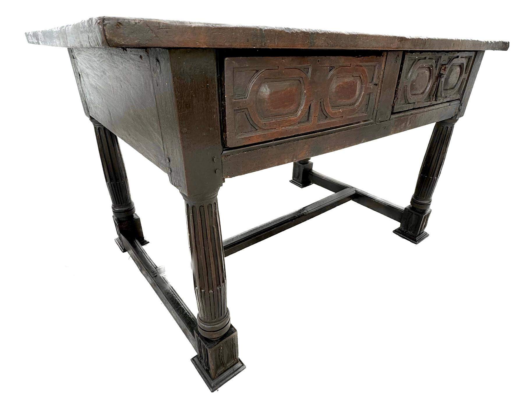 17th century Italian work table with two Carved front drawers and H-shaped stretcher base with turned and fluted legs. Really nice carved fluted columns and drawer fronts with original iron hardware. Wonderful patina and an old world ambience. 
