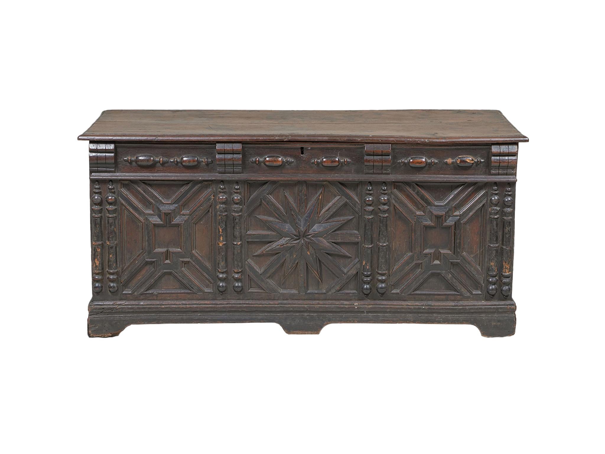 Fabricada en el siglo XVII, esta arqueta jacobea se hizo a mano con madera de roble. La madera tiene un tono cálido y quemado. Ha envejecido maravillosamente a lo largo de los siglos y ha acumulado texturas que añaden carácter e historia al arcón.