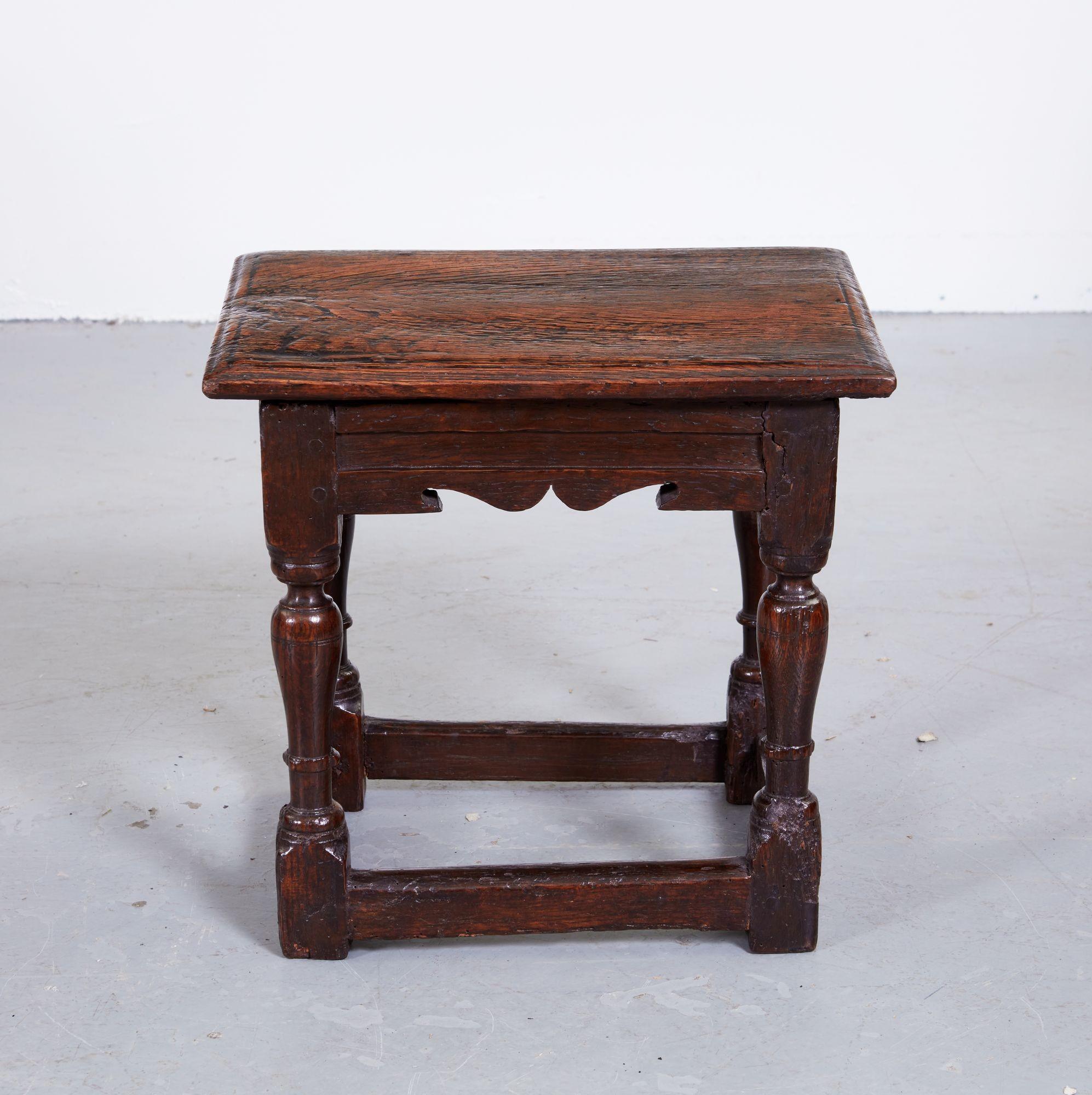 Rare 17th century English small table, also known as a child's joint stool, the single plank top with bead molded edge over molded stretchers with scalloped edge, standing on reverse vase turned legs joined by box stretchers, the whole possessing