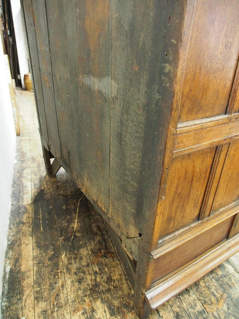 Impressive Dutch oak armoire or cabinet, circa late 1600s. The stepped cornice has rosewood and ebony inlay, ebony panels and three carved figureheads. There are two impressive panelled doors with central raised ebonized panels and three integral,