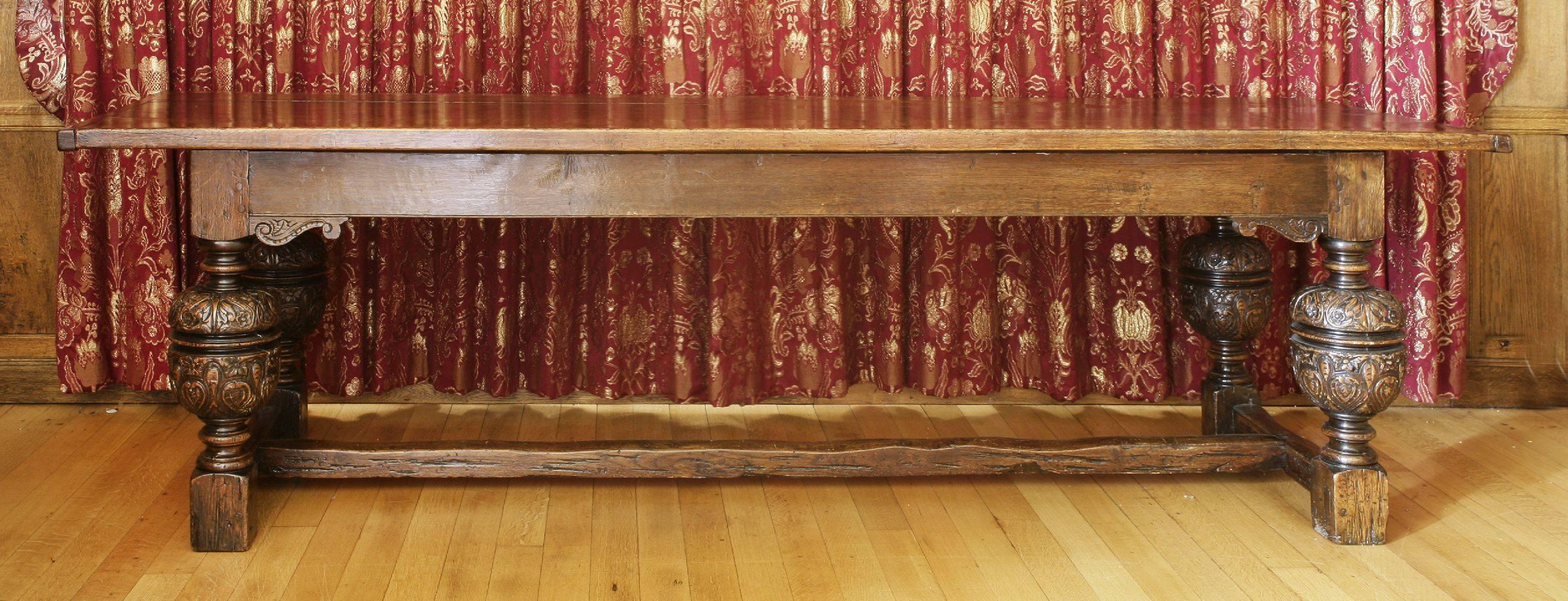 For sale is a very good quality 17th century solid oak refectory table, with a three plank top and cleated ends, above a plain frieze with applied carved corner mounts above four very well carved turned baluster legs and a low centre 