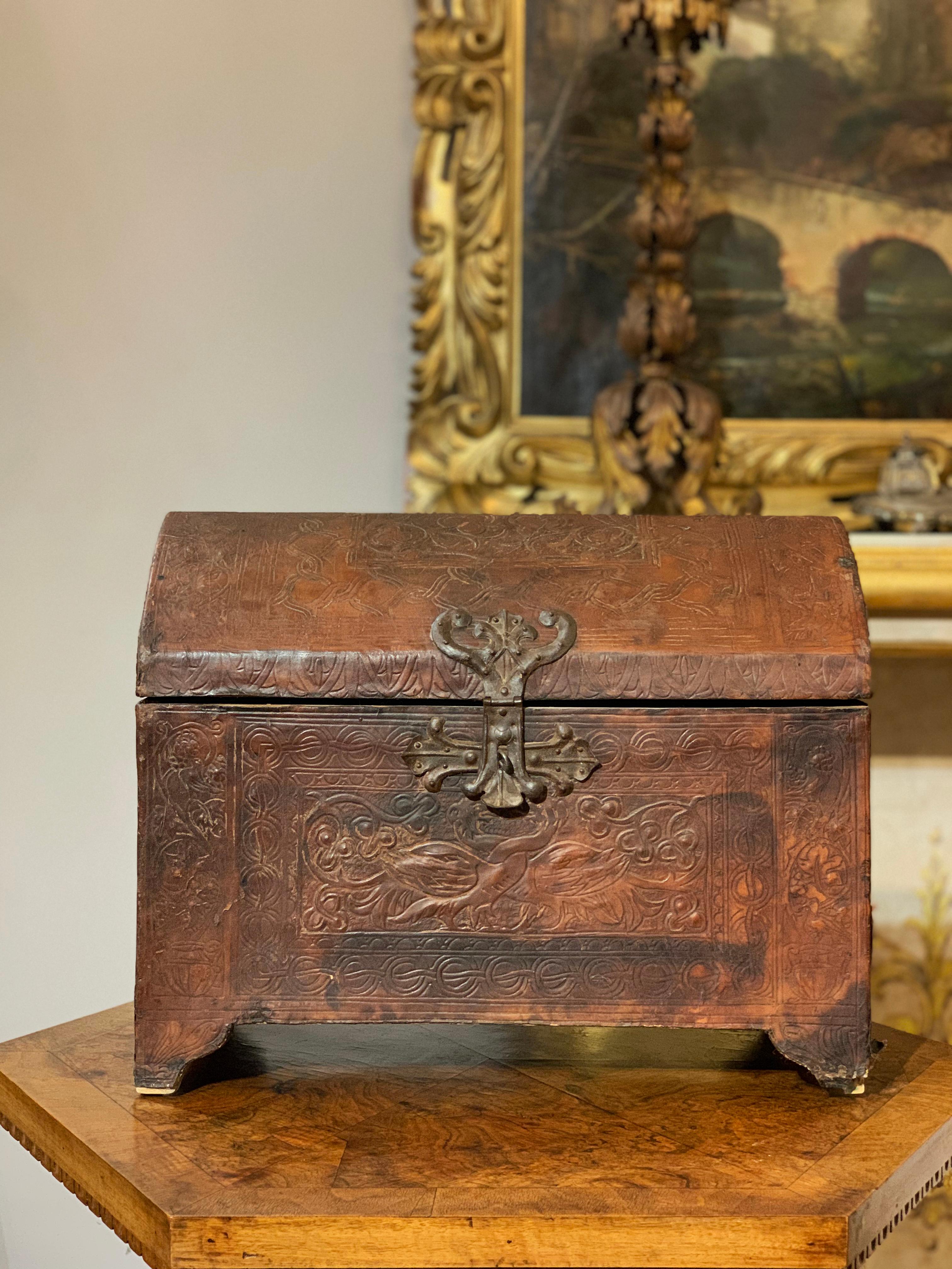 Particular little wooden candle holder case covered in fire-branded leather, with bronze hinges. The cassina features floral and gemometric decorations that create boxes within which zoomorphic images are depicted such as two intertwining peacocks