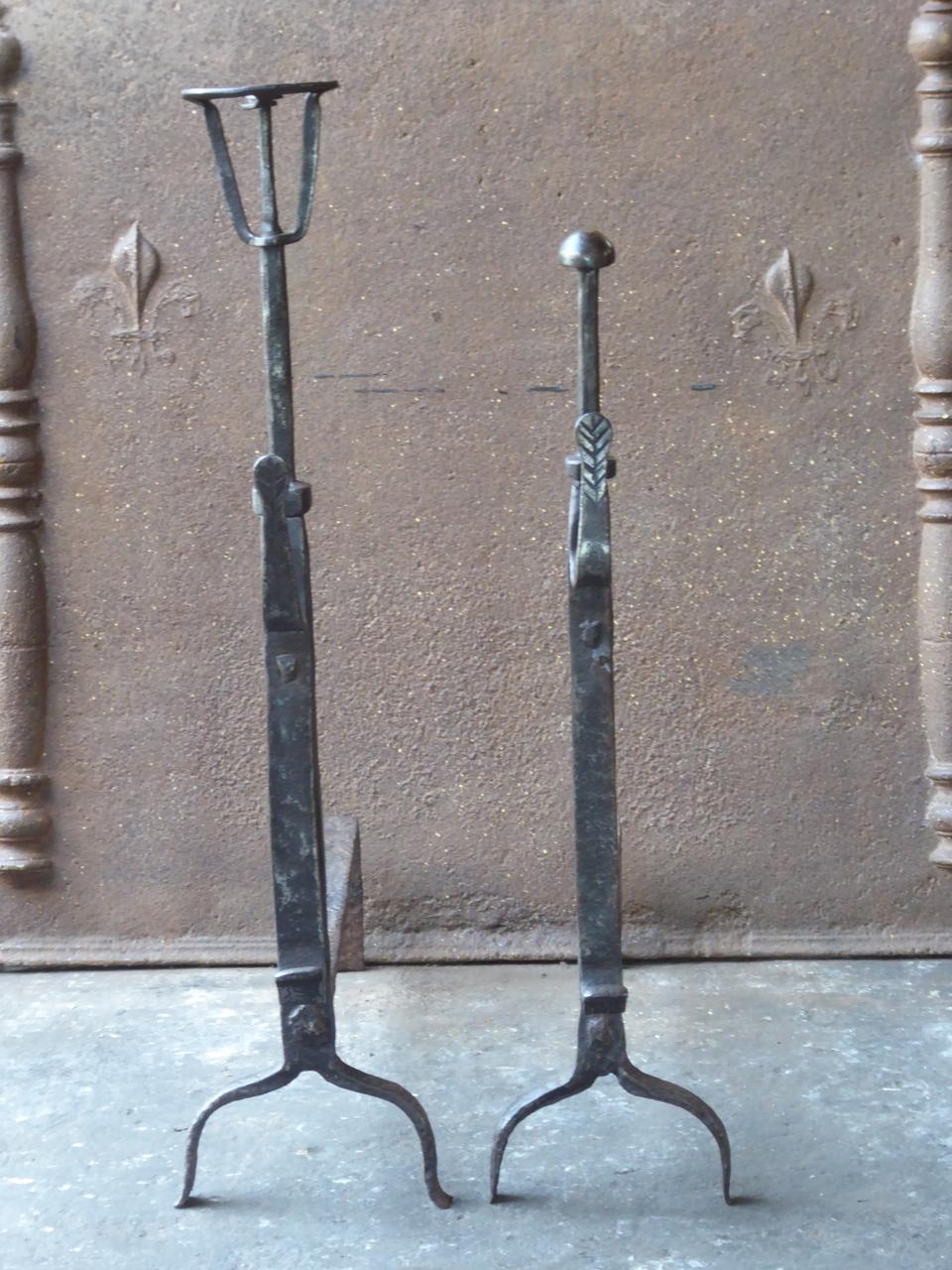 Wedding pair of andirons whereby both parties donate one andiron from the same blacksmith. With spit hooks. These French andirons are called 'landiers' in France. This dates from the times the andirons were the main cooking equipment in the house.