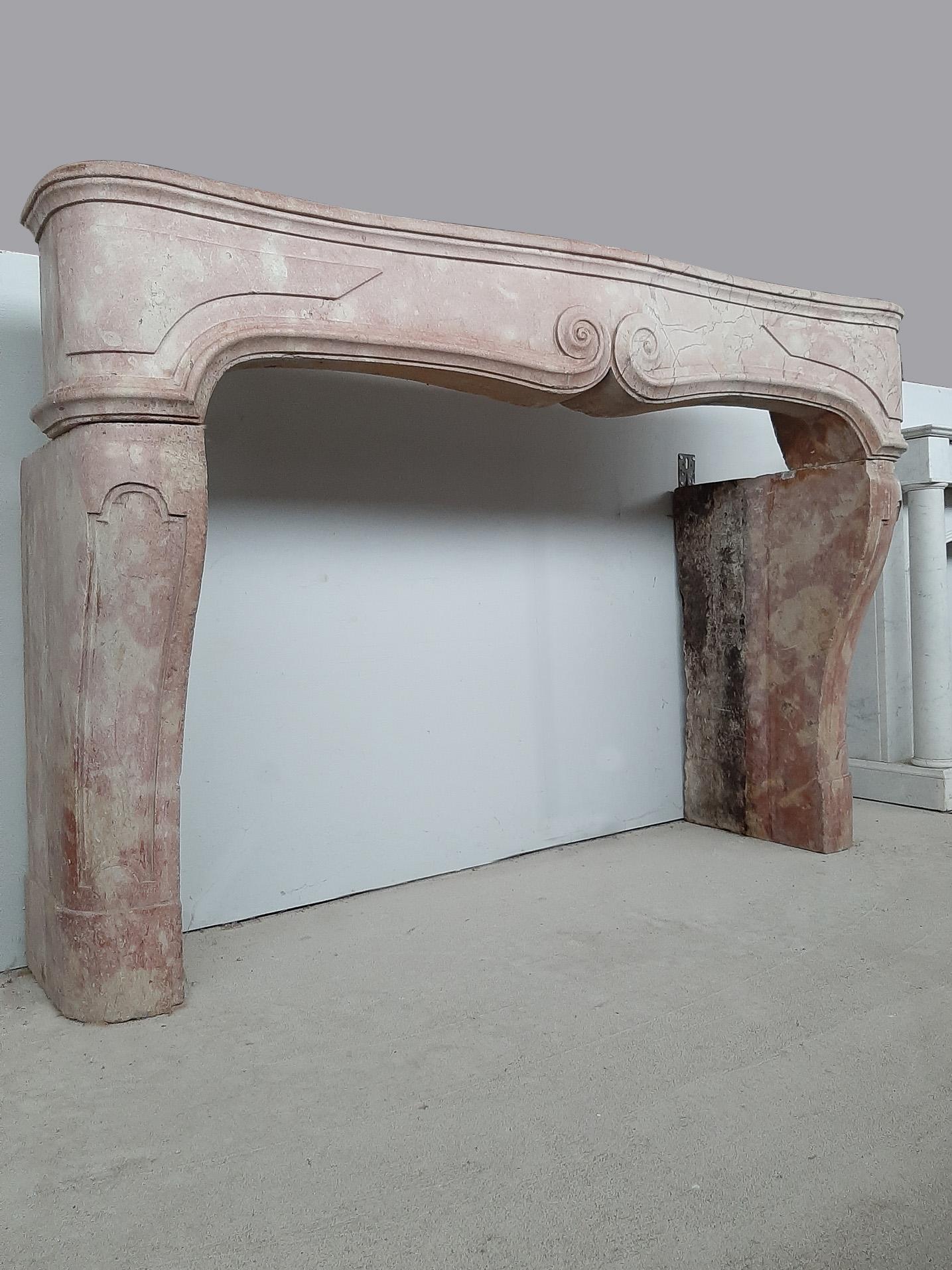 17th century Louis XIV pink marble fireplace, ± 1680. Antique French Burgundian mantelpiece with a decorative brace in the frieze and with panels in the legs.

Dimensions: H 122 x W 180 x D 55 cm, depth at the top 29 cm
Inner dimensions: H 95 x