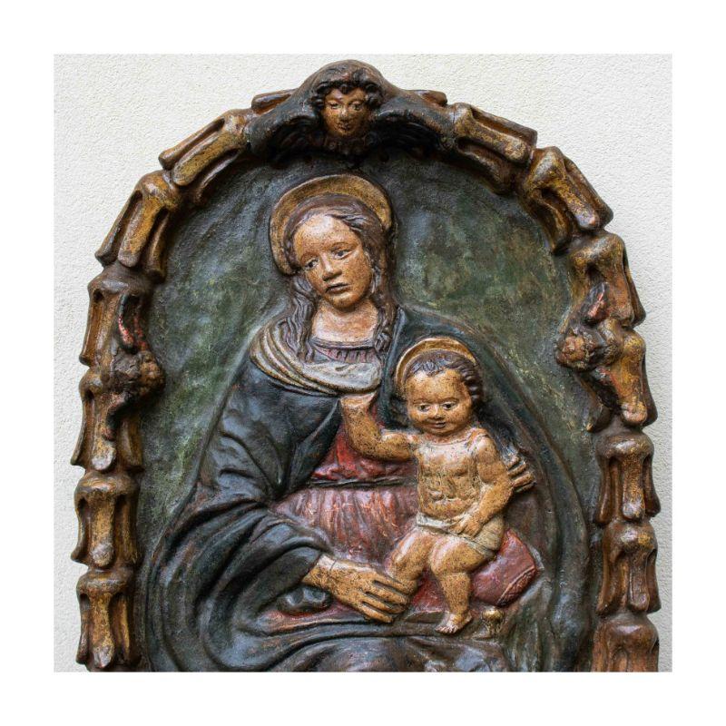 Toskanische Schule, 17. Jahrhundert 

Madonna mit Kind - aus der Impruneta Tondo

Maße: Polychrome Terrakotta, 65 x 46 x 10 cm

Dieses polychrome Terrakottarelief, das sich sanft in einer modellierten Virtuosität erhebt, die eine heitere