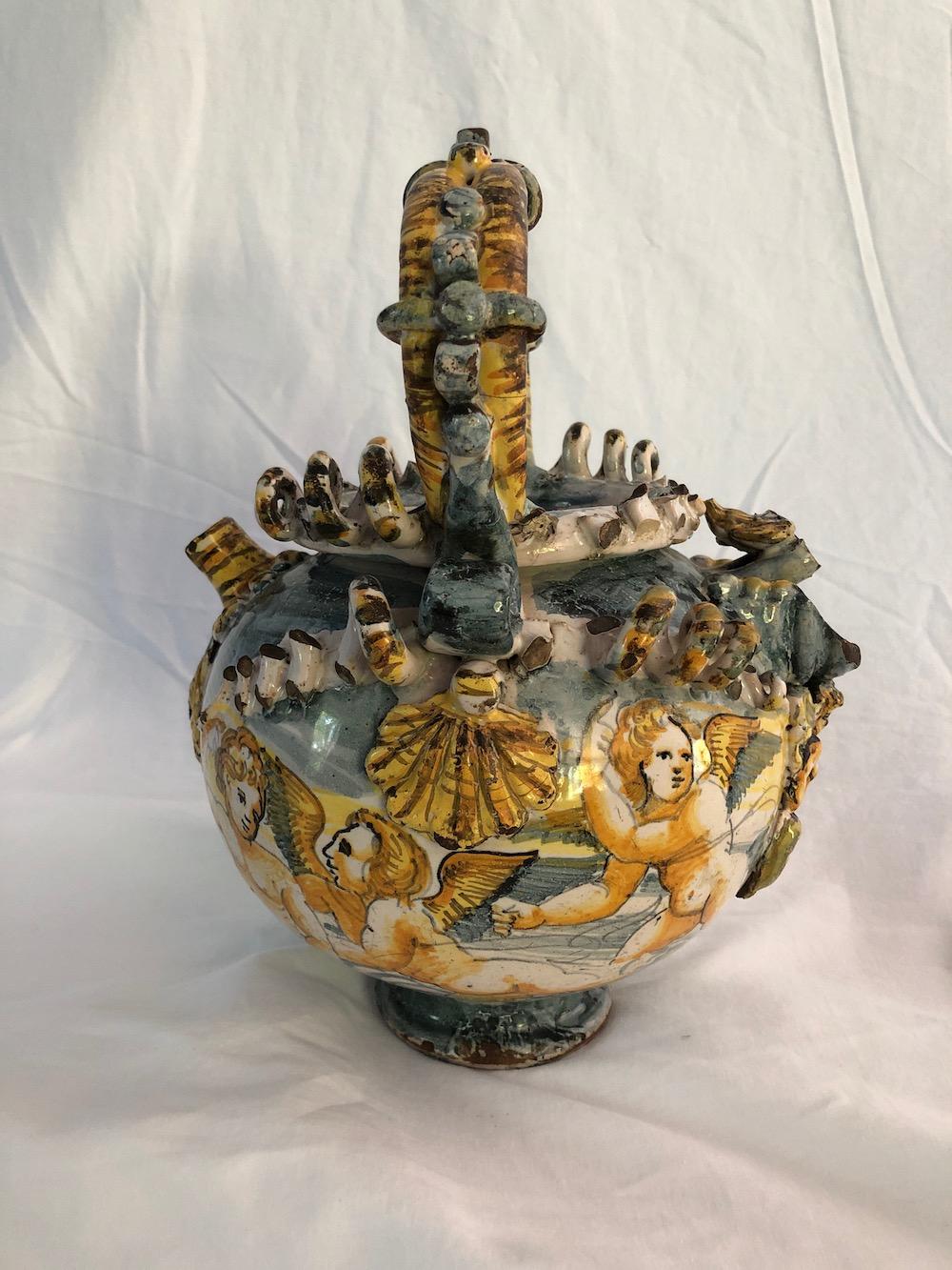 17th century Majolica wet drug jar with cupids in relief. Good condition but has several cracks for due to its age. Sold as is.