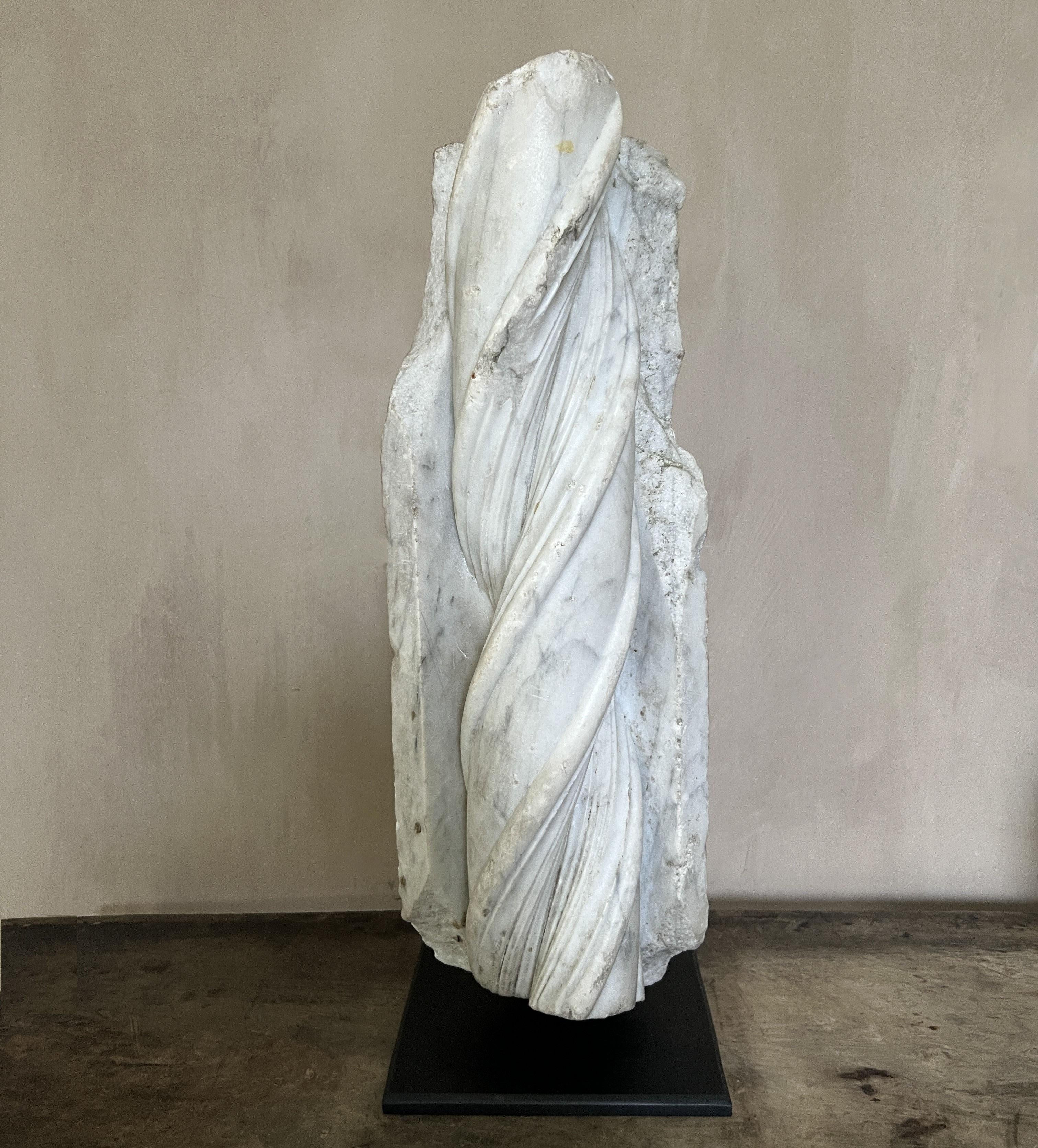 Frammento architettonico del XVII secolo, probabilmente parte di un colonnato o di una porta scolpita. Con un pane a spirale tra due angeli dritti scolpiti meticolosamente e abilmente. Come oggetto funziona bene con il suo contrasto tra movimento e