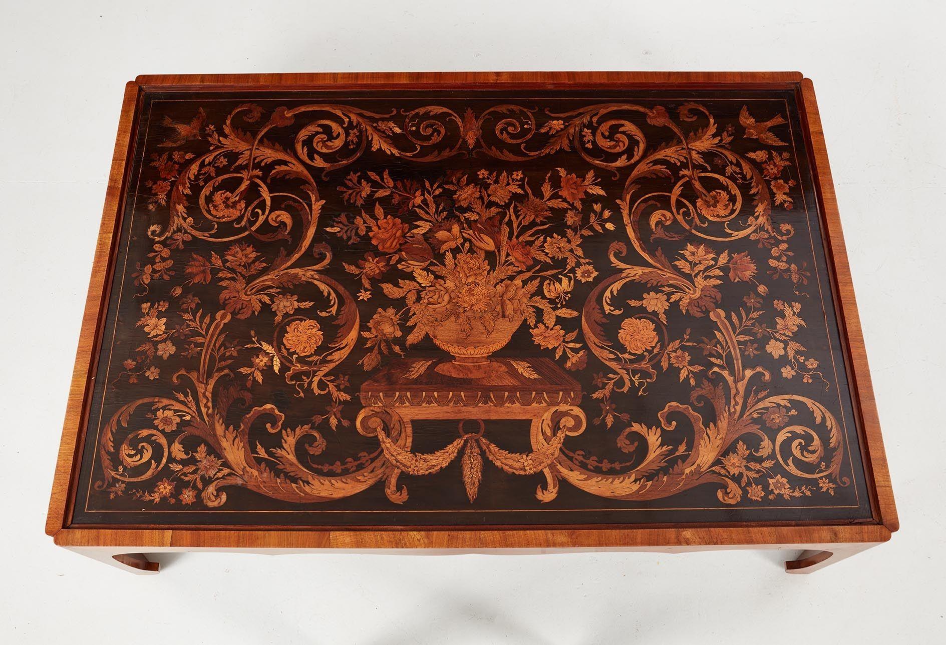 Remarkable 17th Century French marquetry panel now incorporated into a coffee table, the top elaborately inlaid with walnut, olive, fruitwood, ebony, holly, sycamore and other woods depicting a central flowering urn on pedestal amidst a sea of