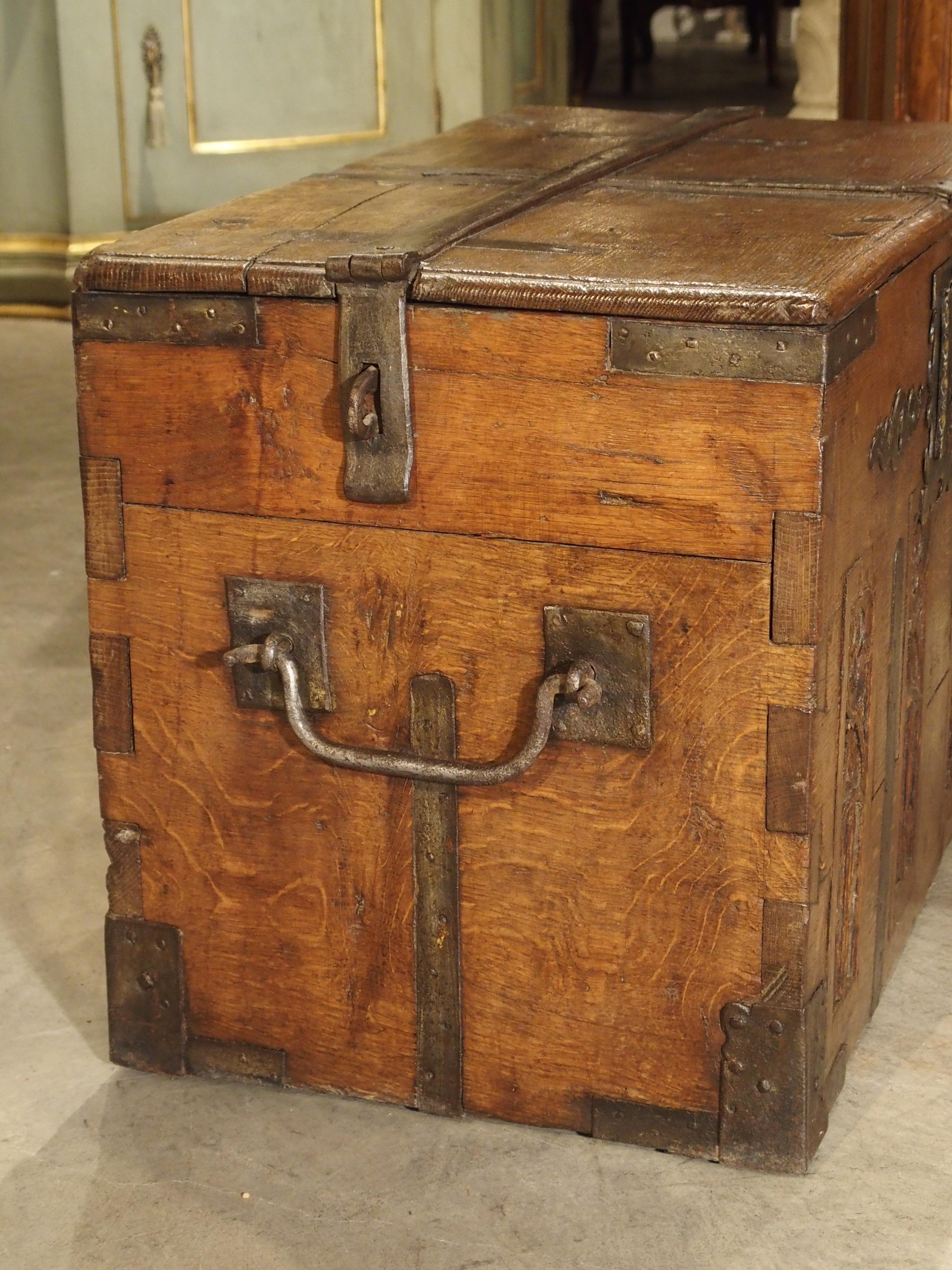 This iron bound, antique oak trunk from the 1700s has four inset panels at the front with Gothic ornamentation. The trunk must have held very important valuables at one time, as there are three locks on the front panel and the ability to pad lock
