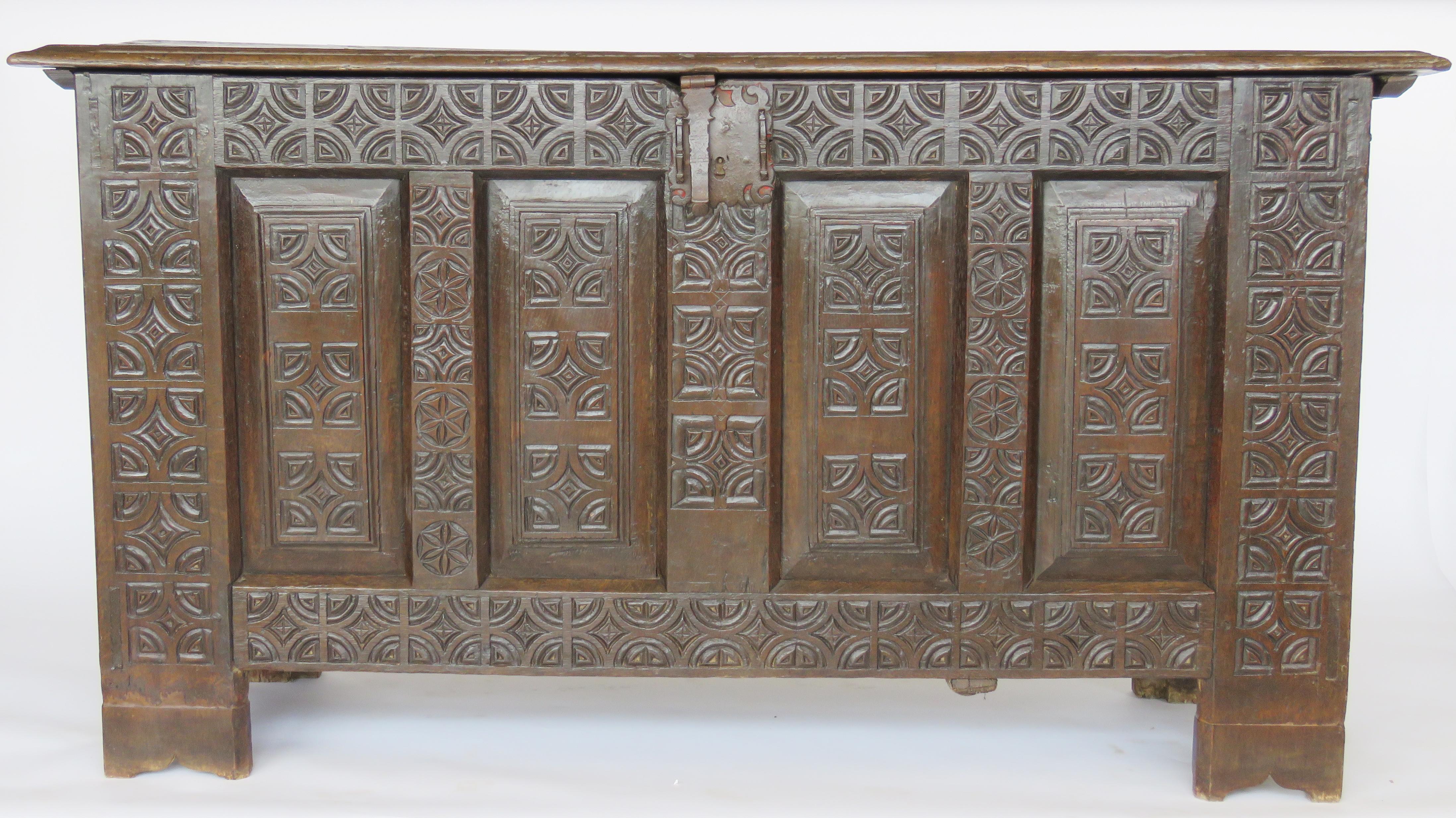 Rectangular hinged molded top over conforming case, front panel deeply carved with geometric motifs, molded panelled sides; original shield lock and hardware.