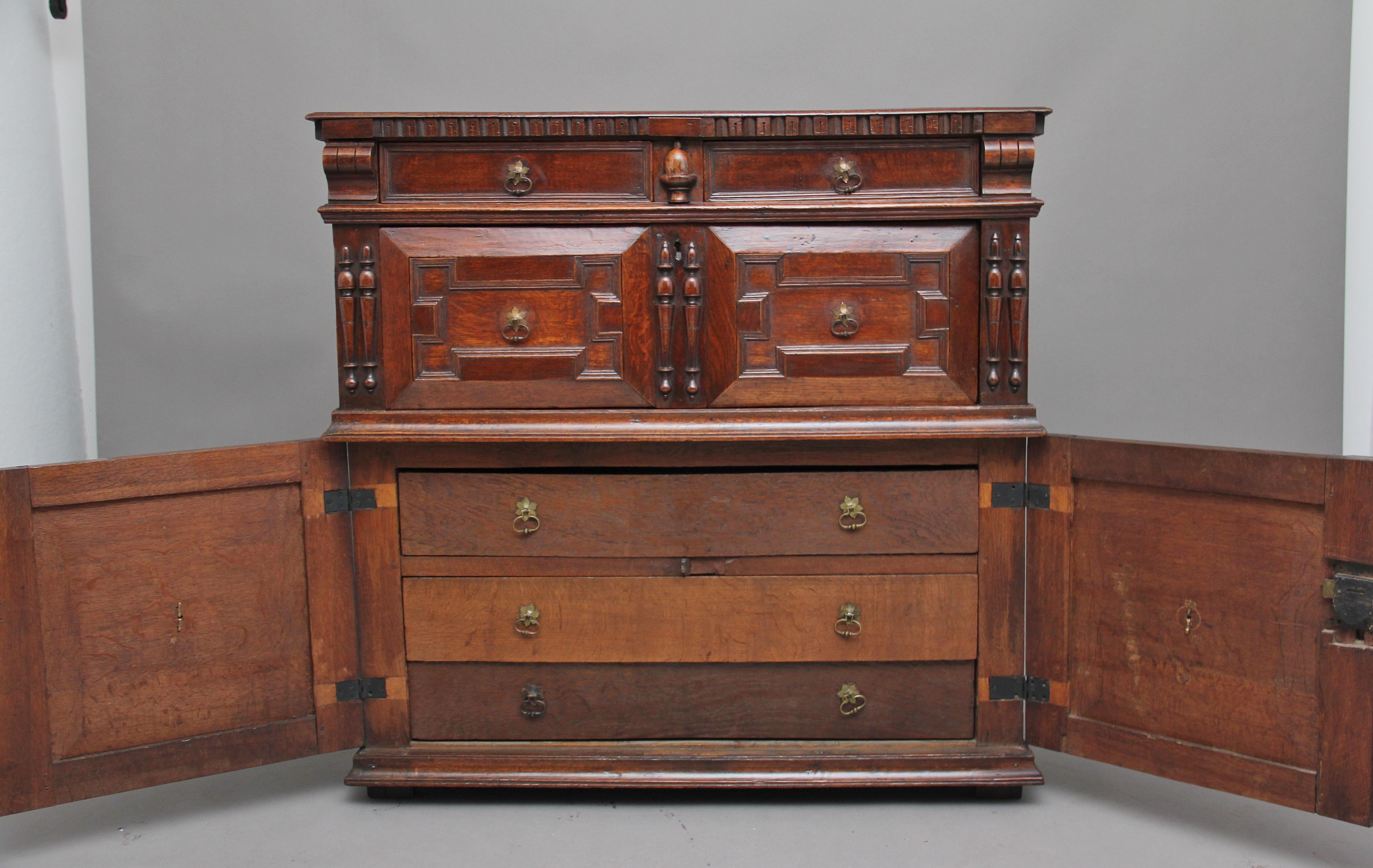 A lovely quality 17th century oak part enclosed chest of drawers, the moulded rectangular top having dentil frieze over two short drawers, each with moulded fielded panels flanking split acorn moulding, a geometric deep drawer below with parallel