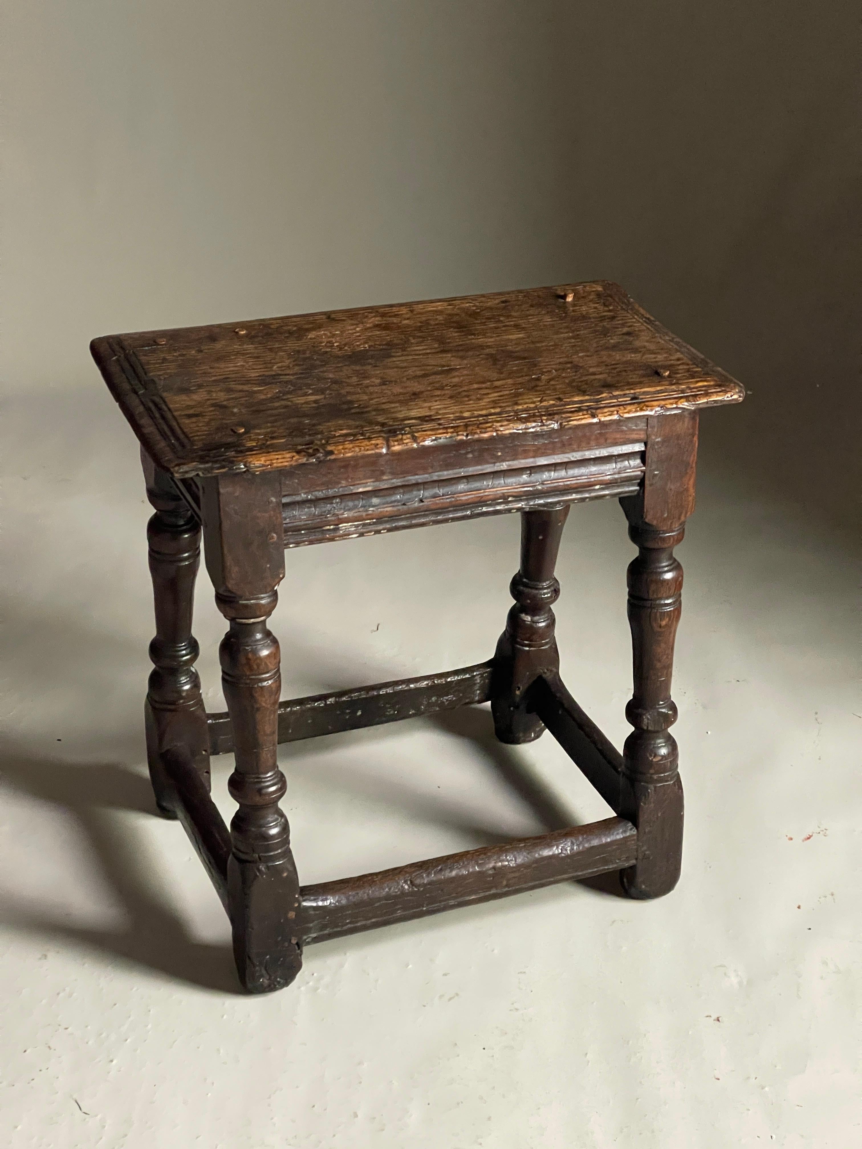 17th Century oak joined stool of good colour and patination and original condition well turned legs size top 49cms x 27 and 49 high.