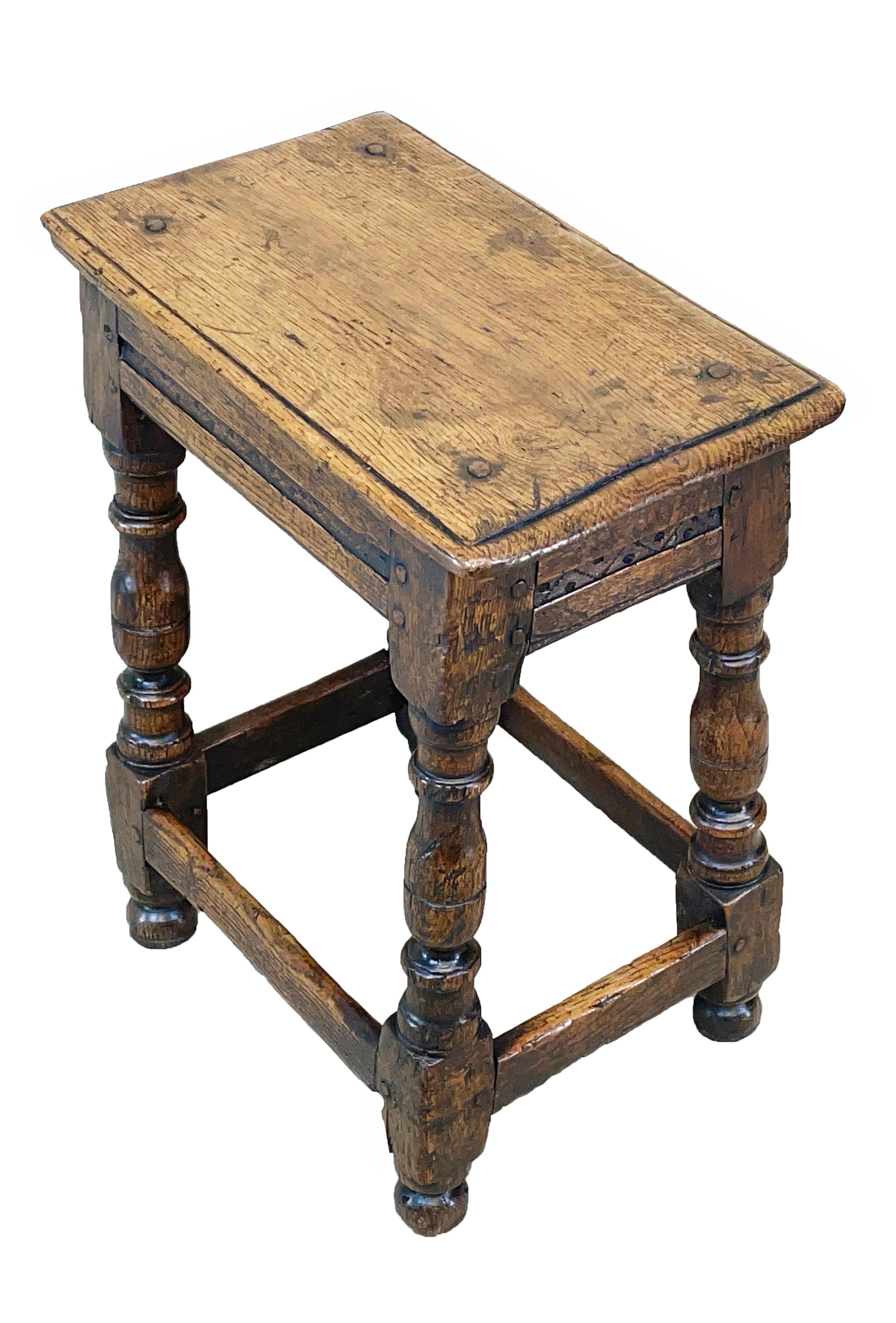 A charming 17th century Charles II period oak
Joint stool having single plank top over
Seat rails with attractive carved decoration
Raised on elegant baluster turned leg
Supports with plain stretchers retaining
Exceptional color and patina
