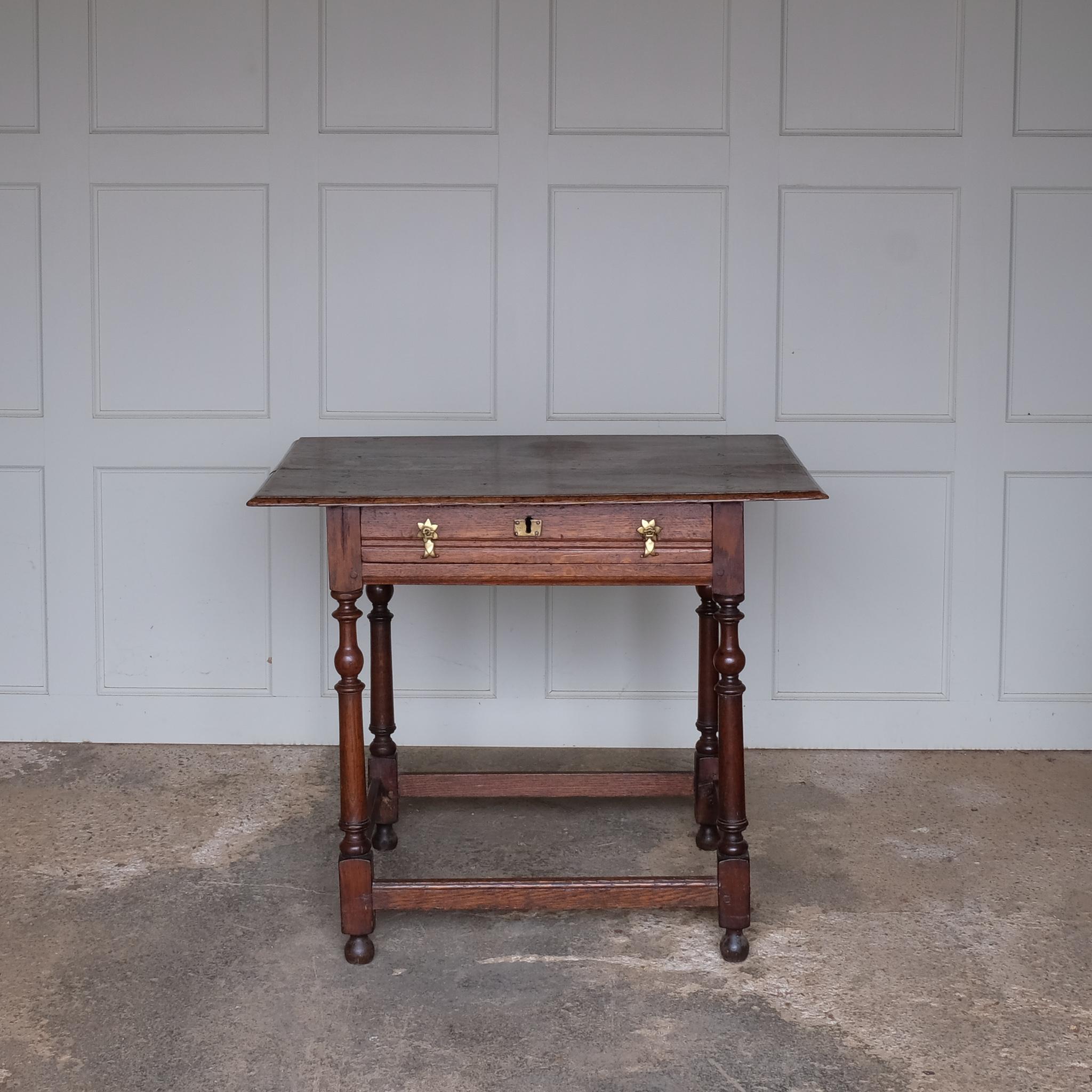A fine 17th century English oak side table with a lovely well-patinated two plank moulded top with with flying overhangs above a single drawer over tapered and ring-turned legs joined by box stretchers. A very useful size for use in either a living