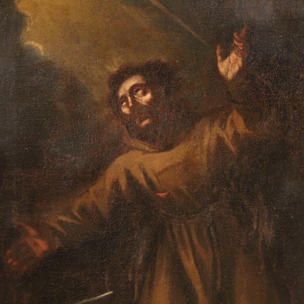Antique 17th-century Italian painting. Oil on canvas artwork with an intense depiction of Saint Francis of Assisi in ecstasy. The saint is depicted in prayer, kneeling, gazing heavenward with outstretched arms as he receives the miracle of the